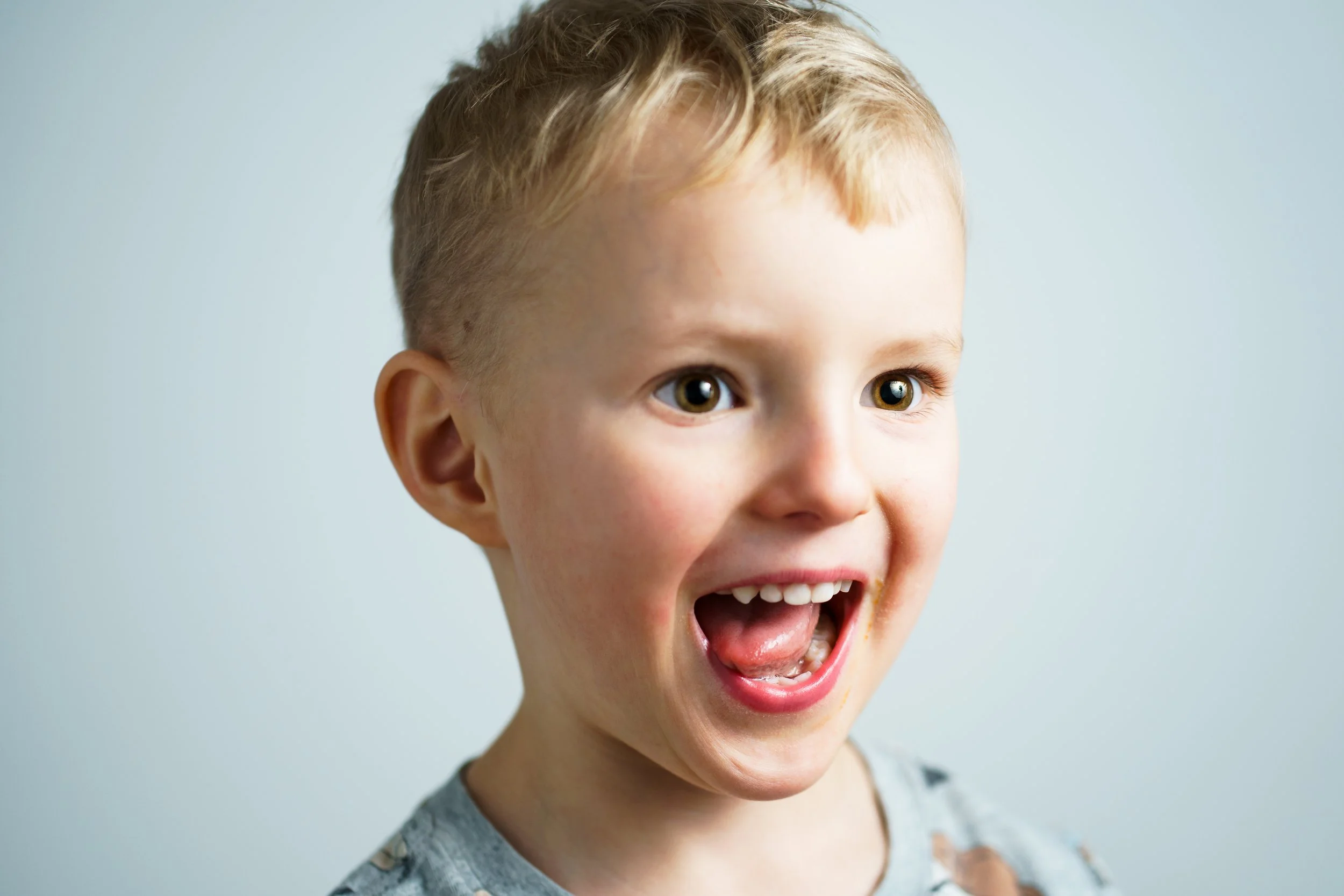 Ung pojke med busig blick fotograferad i en studio.