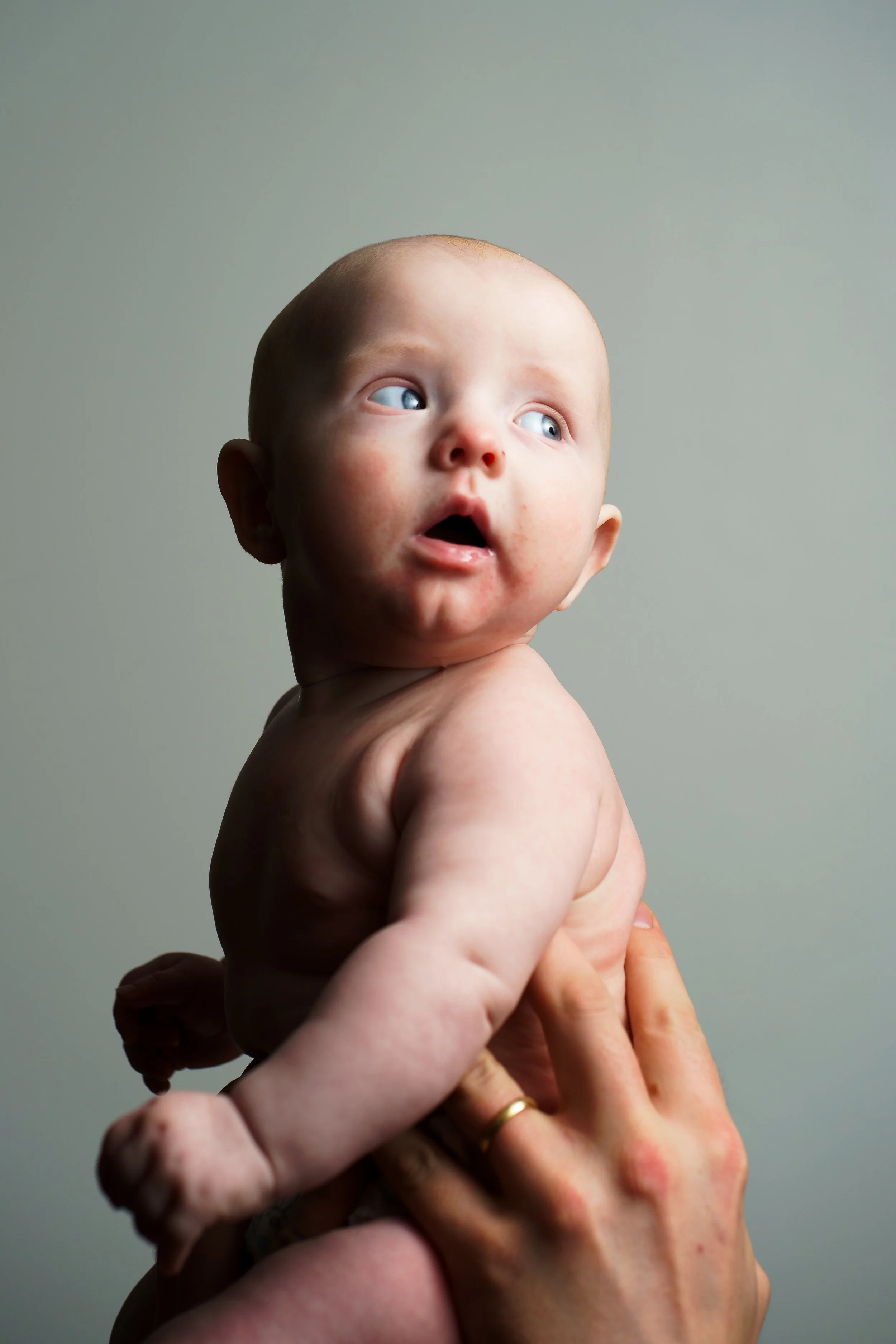 Bebis med nyfiken blick tagen i en fotostudio i hemmamiljö.