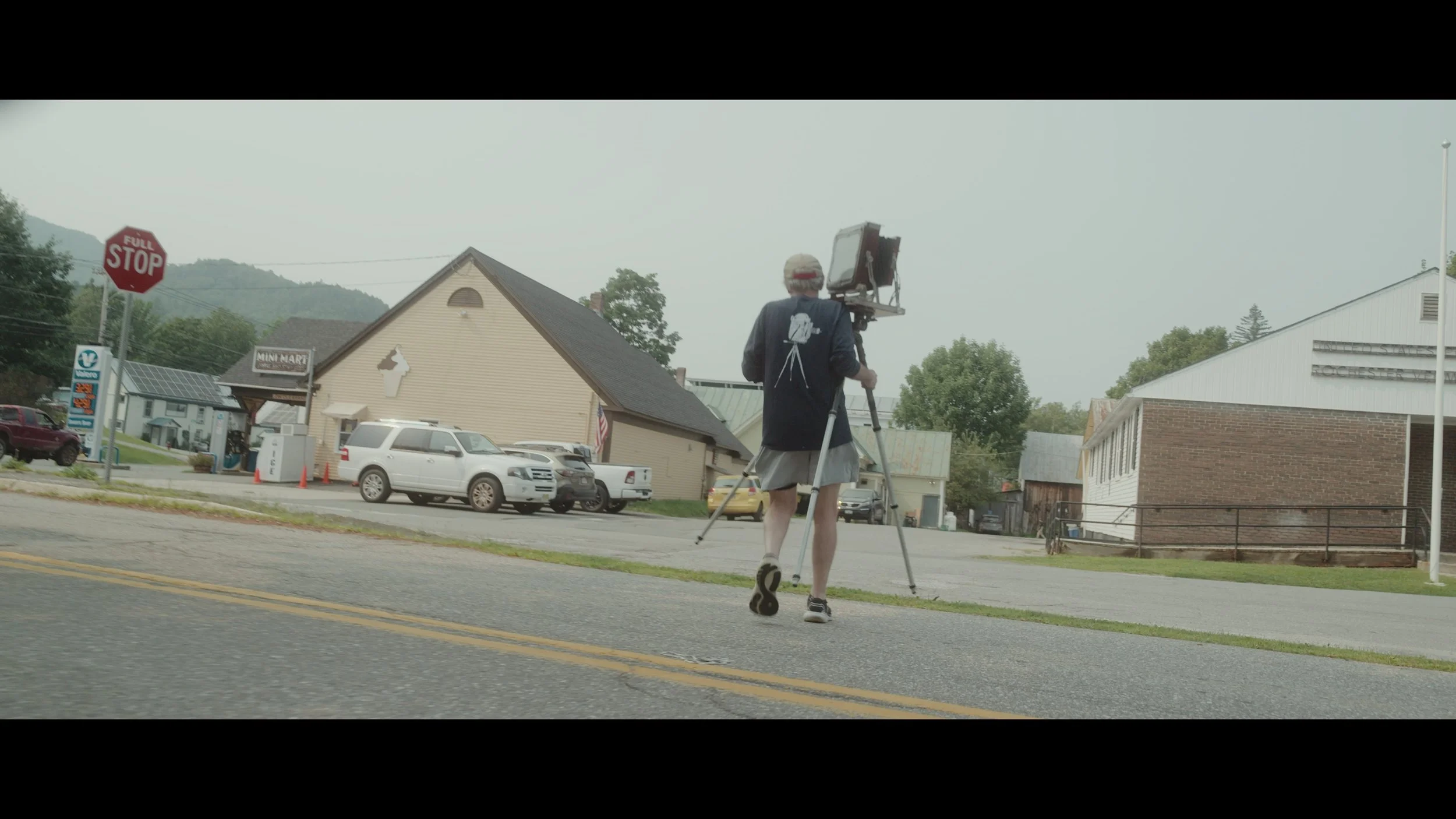 Photographer Jim Dow walking his large format 8x10 camera into position in Rochester, Vermont.