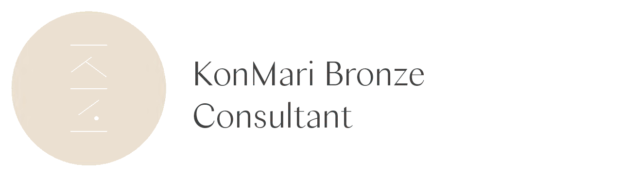 Logo mit einem beige Kreis, darin schwarze, schlichte Linien und Punkte, neben dem Schriftzug 'KonMari Bronze Consultant'.