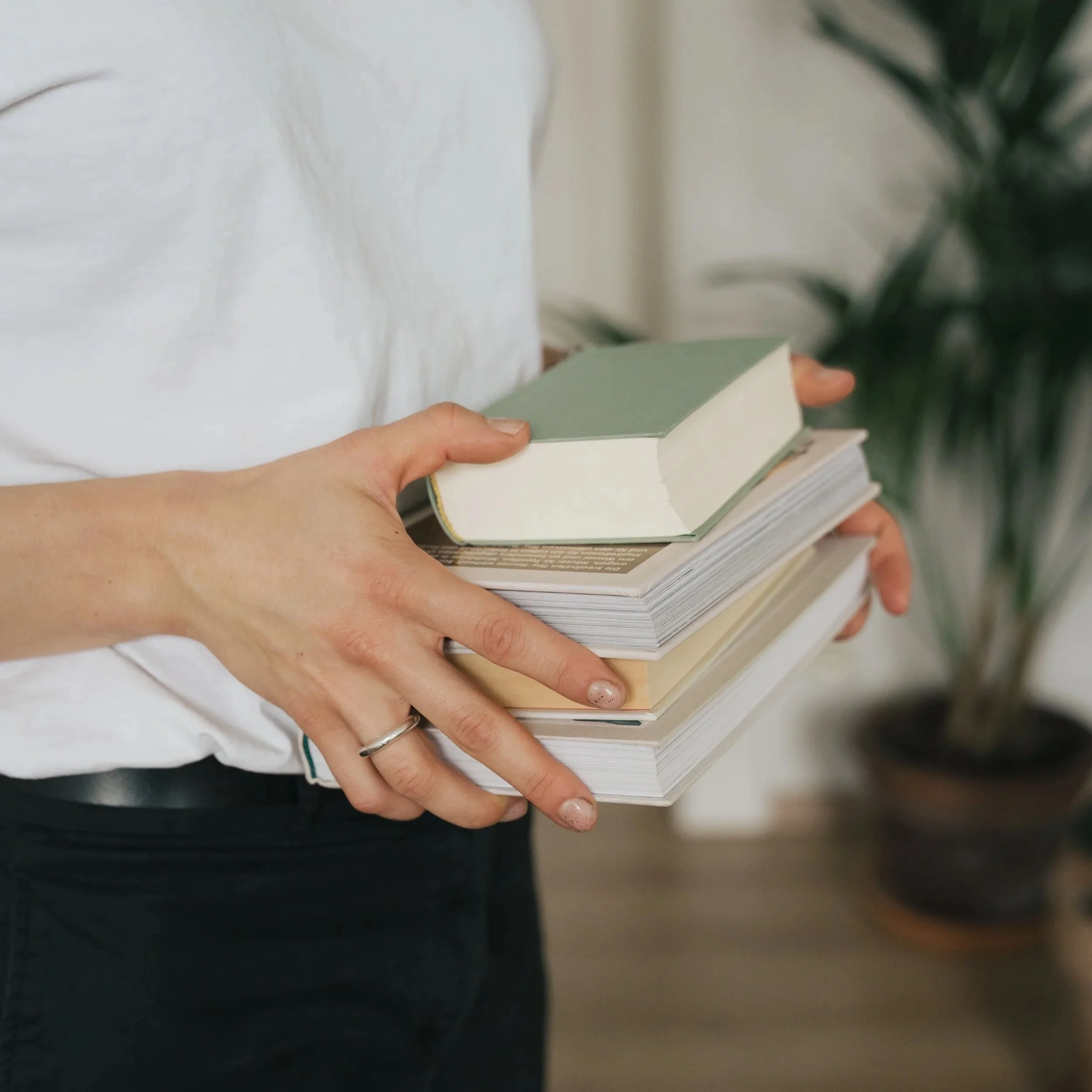 Nahaufnahme einer Hand, die Bücher hält.