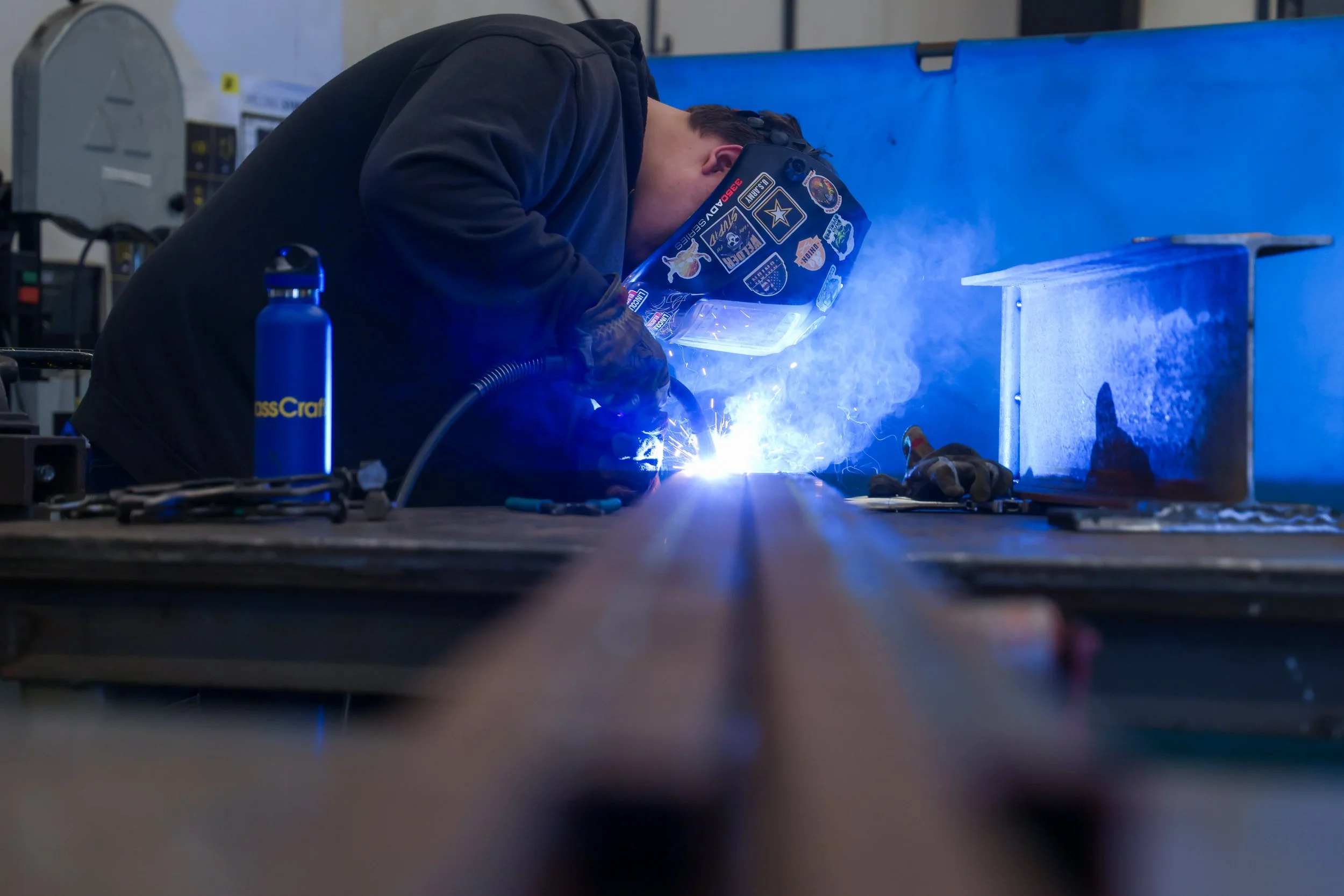 Student leaning over and welding