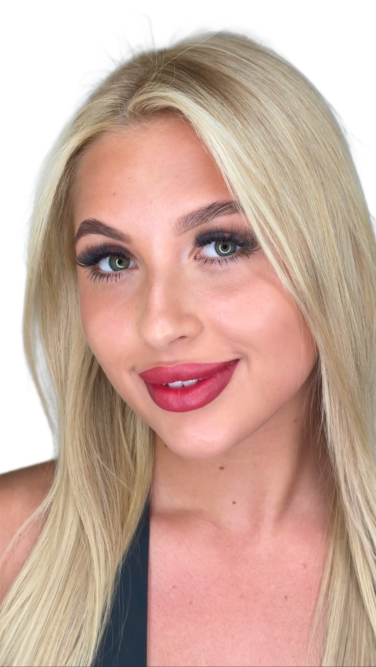 Close-up of a smiling woman with long blonde hair, blue eyes, and red lipstick against a white background.