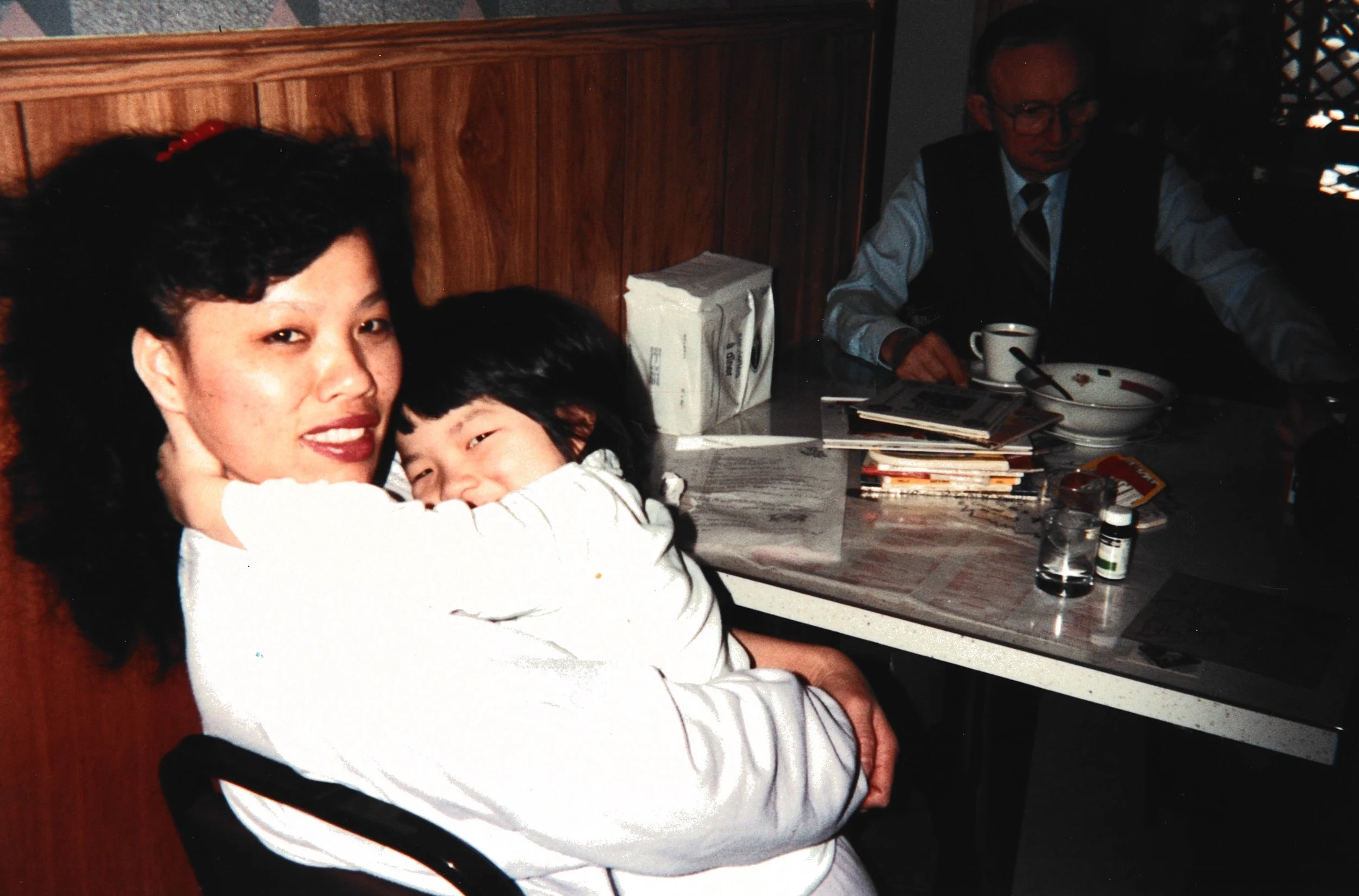 A Chinese family of five pose in front of the bar inside their Chinese restaurant.