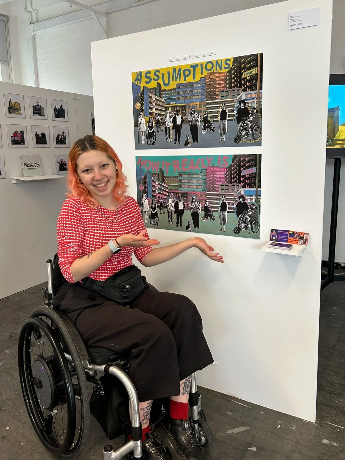 A photo of me, a manual wheelchair user, posing next to the previously described artworks.