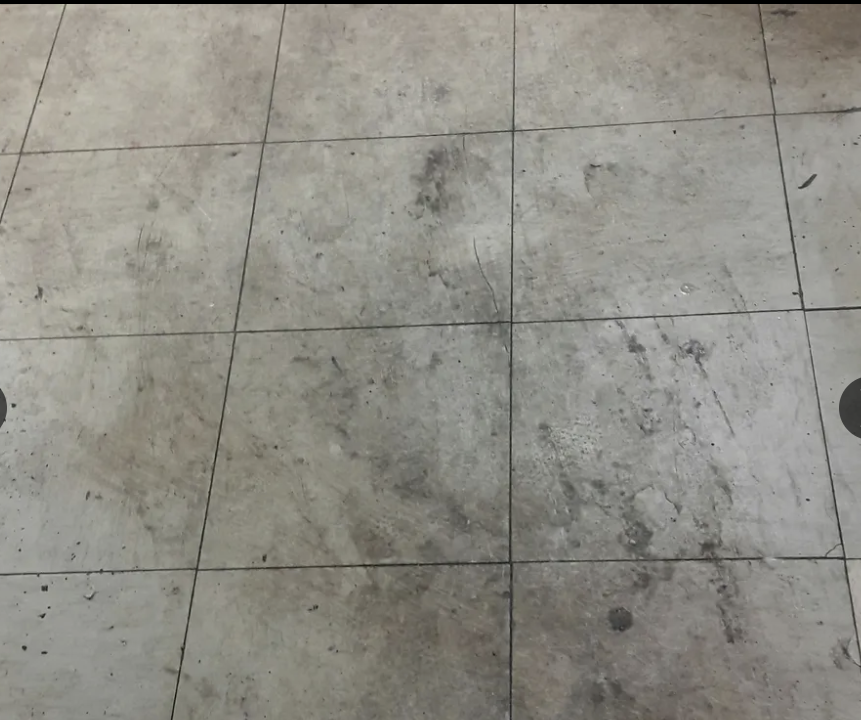 Dirty tiled floor with visible wear and stains.