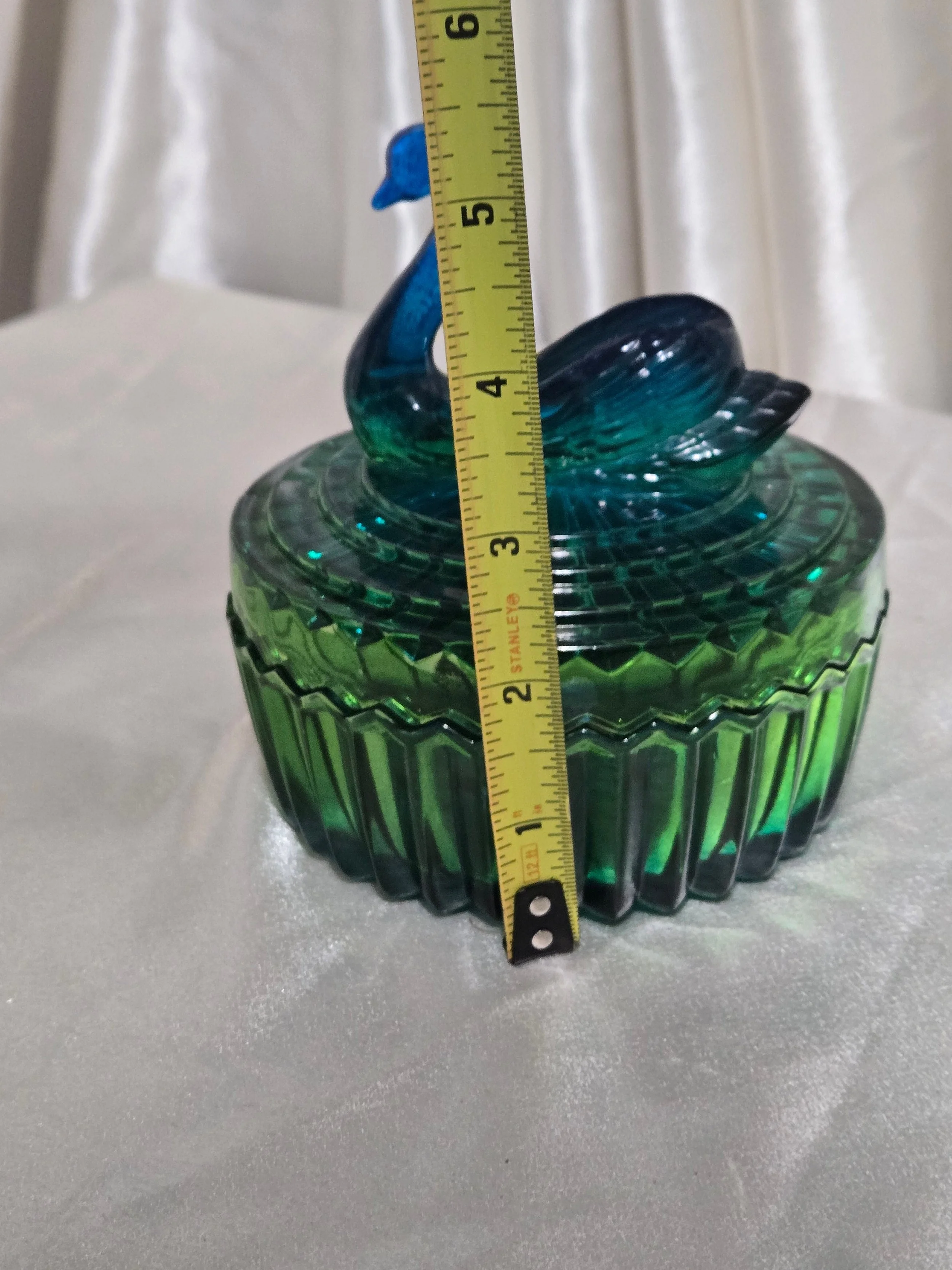 Vintage green glass swan candy dish displayed with measuring tape for size reference