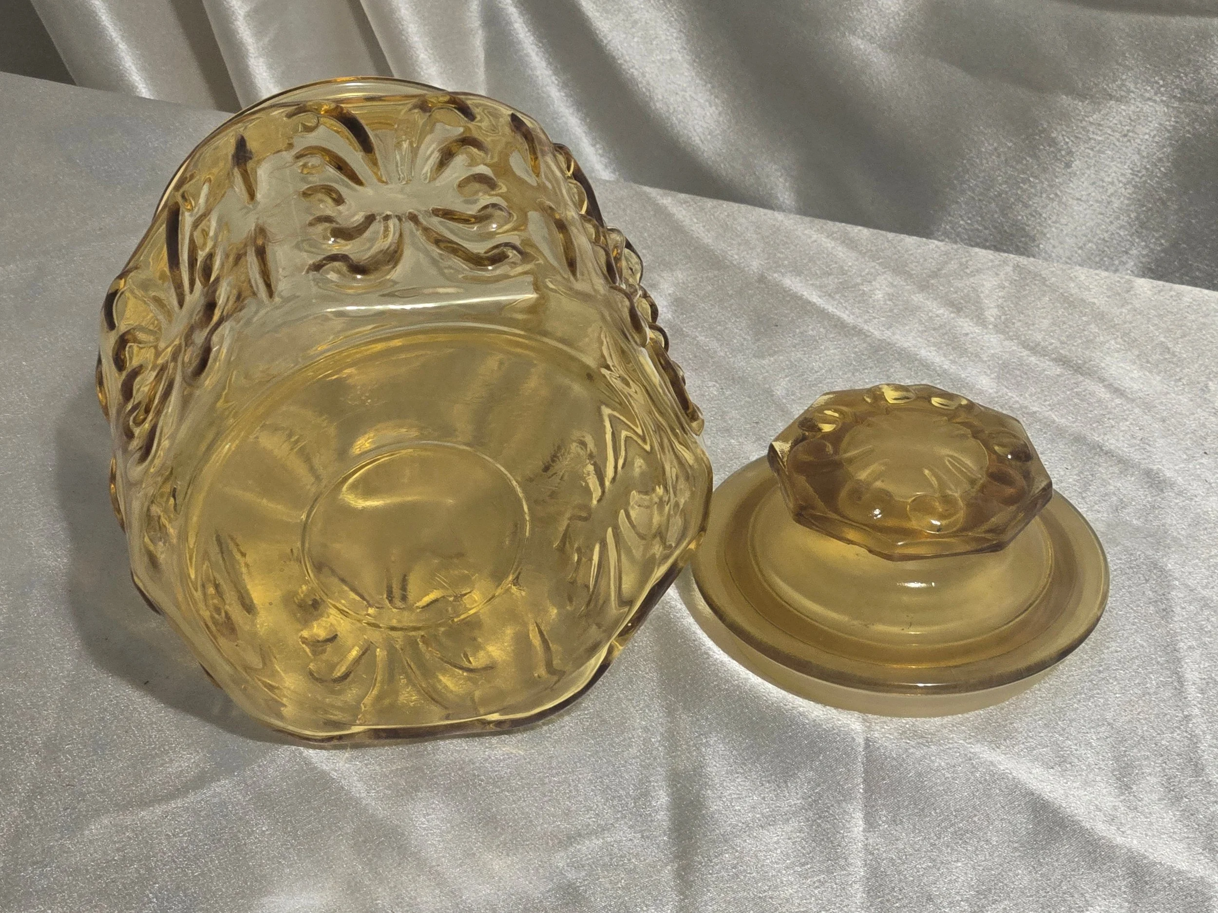 Ornate amber apothecary jar with floral scroll design, retro glass storage