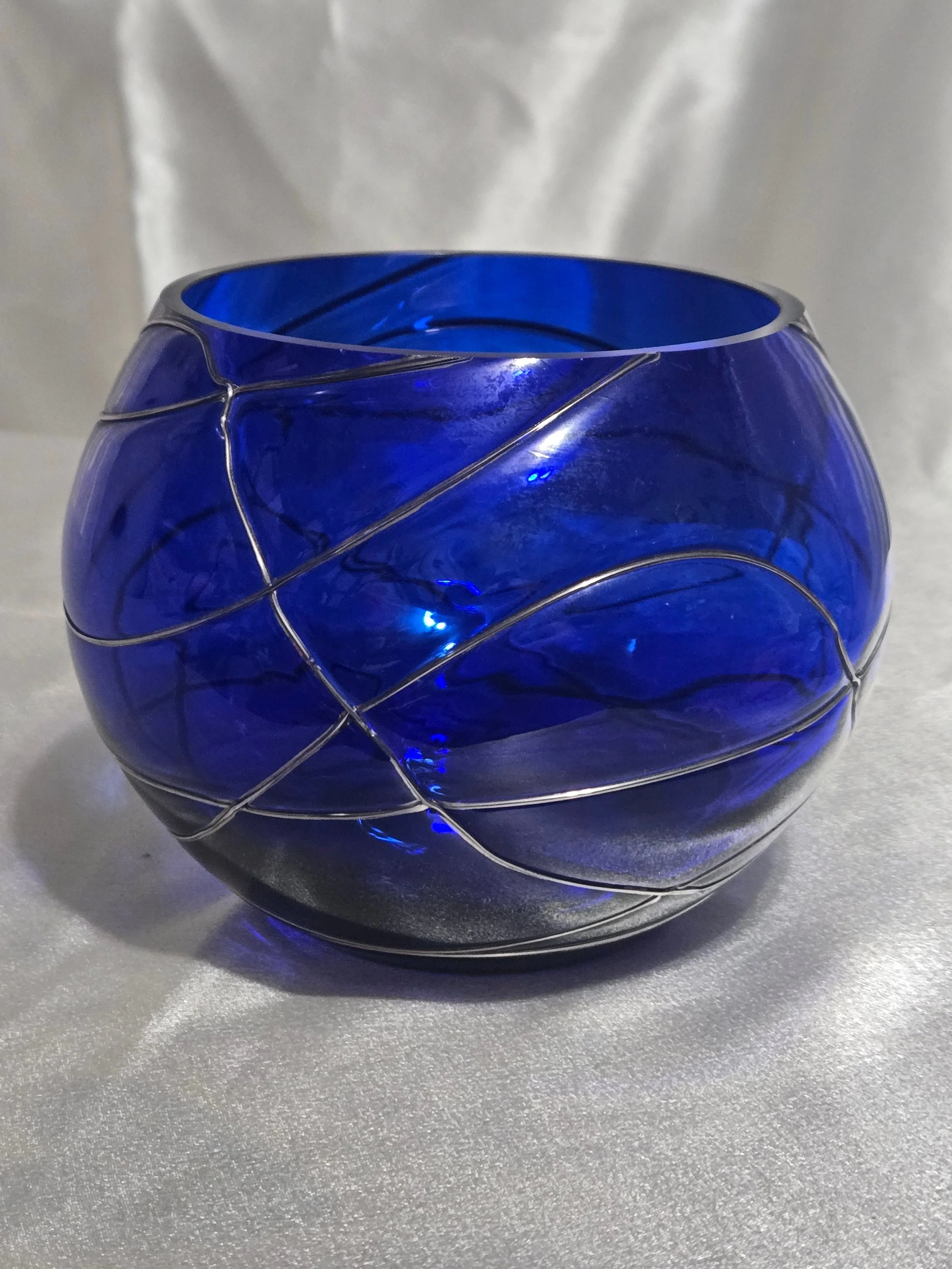 Cobalt blue hand-blown glass vase with silver swirl detailing, rounded art glass bowl, Murano-style decorative piece.