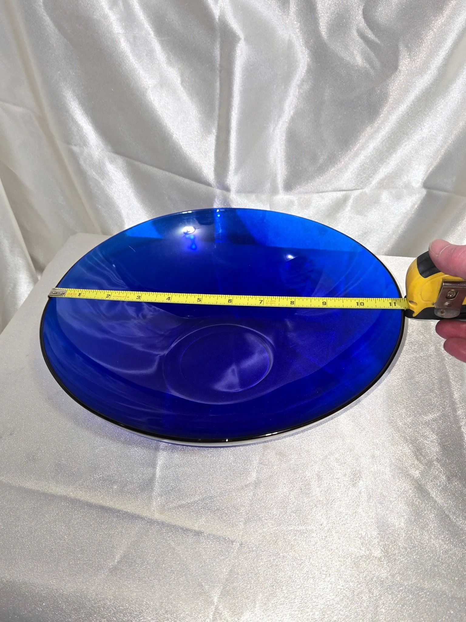Large cobalt blue glass serving bowl displayed on neutral backdrop.