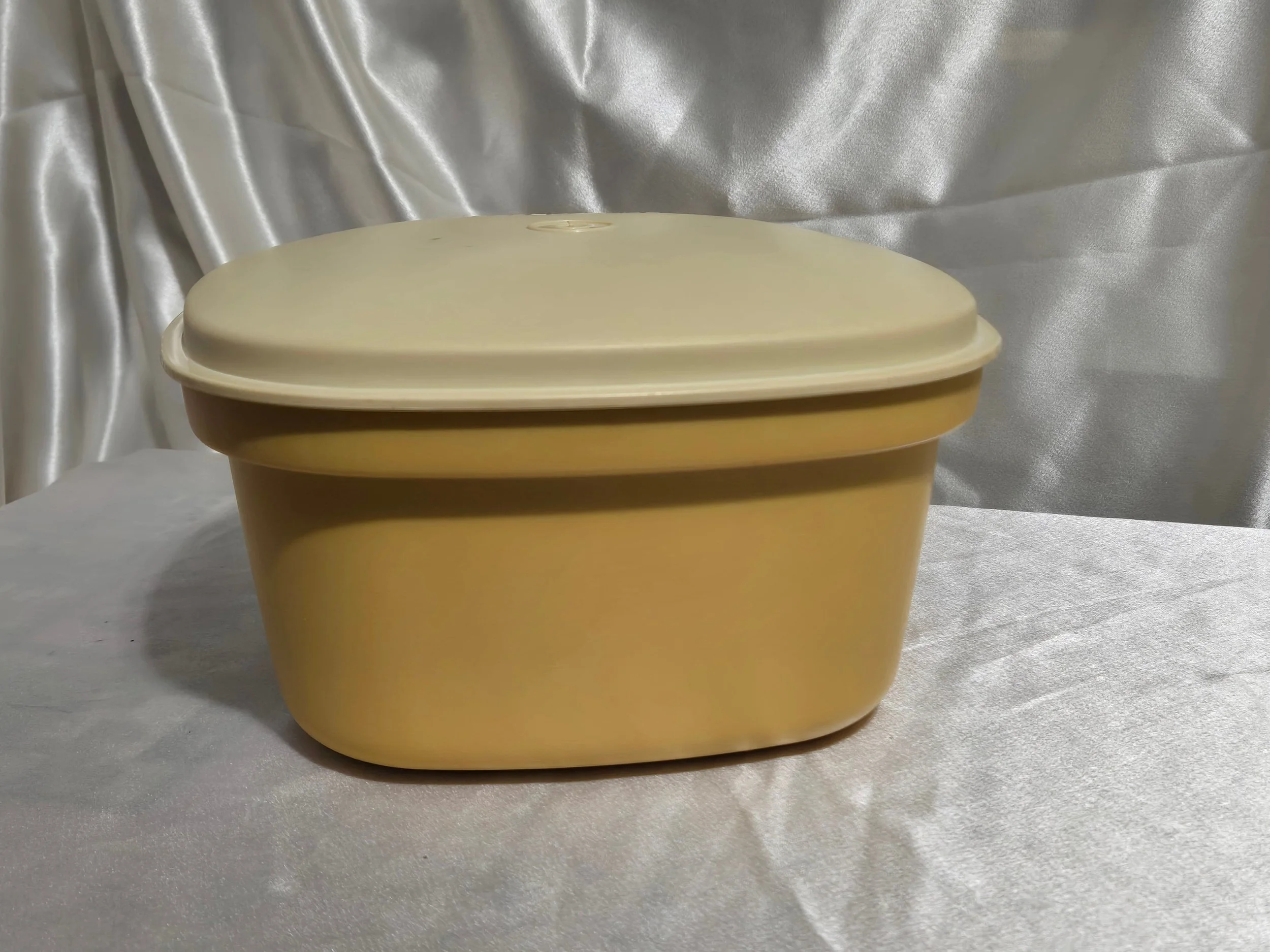 Vintage Tupperware microwave steamer in mustard yellow and ivory with lid, vented insert, and base shown together.