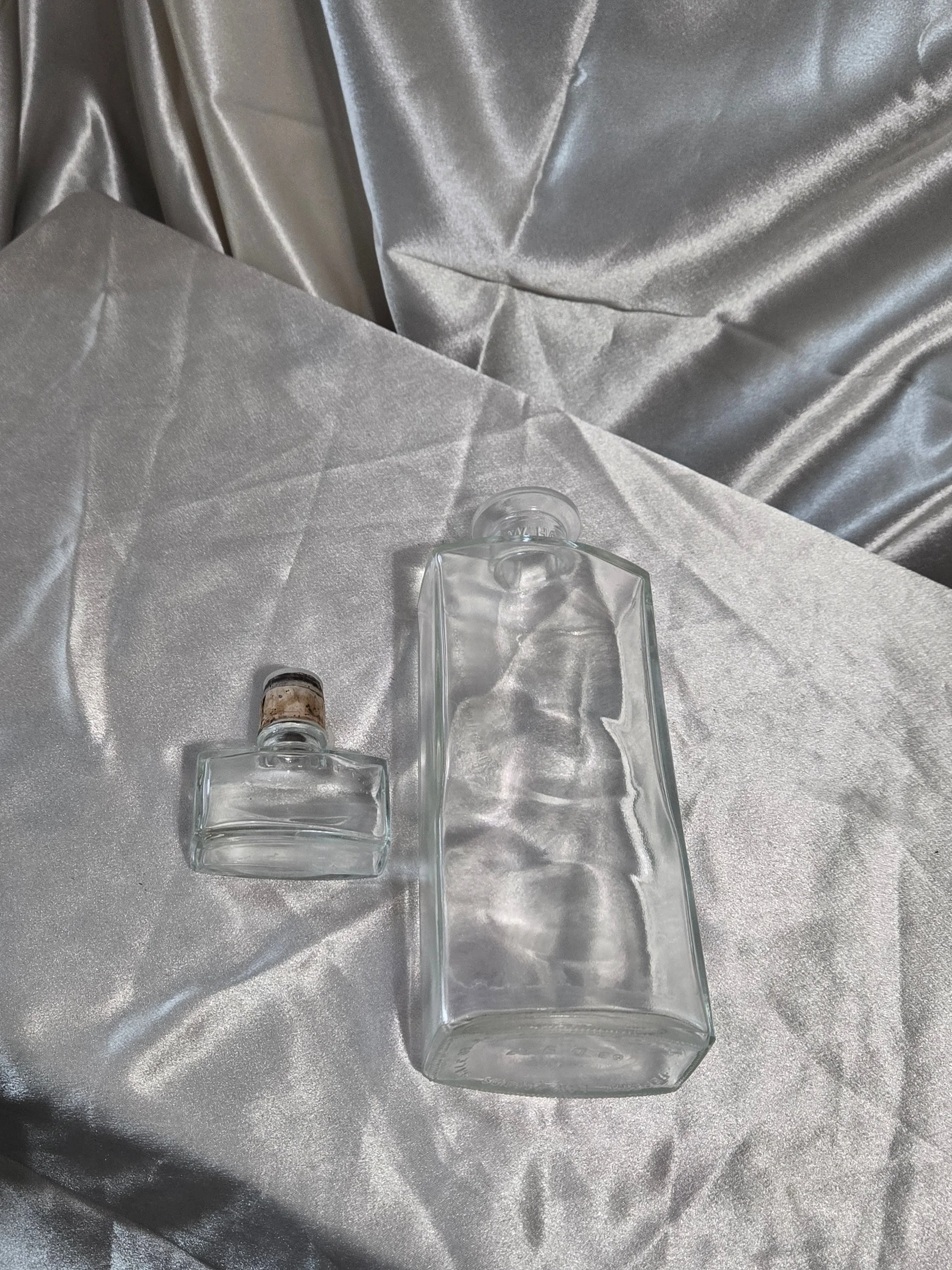 Vintage IW Harper bottle laying flat beside stopper, showing size