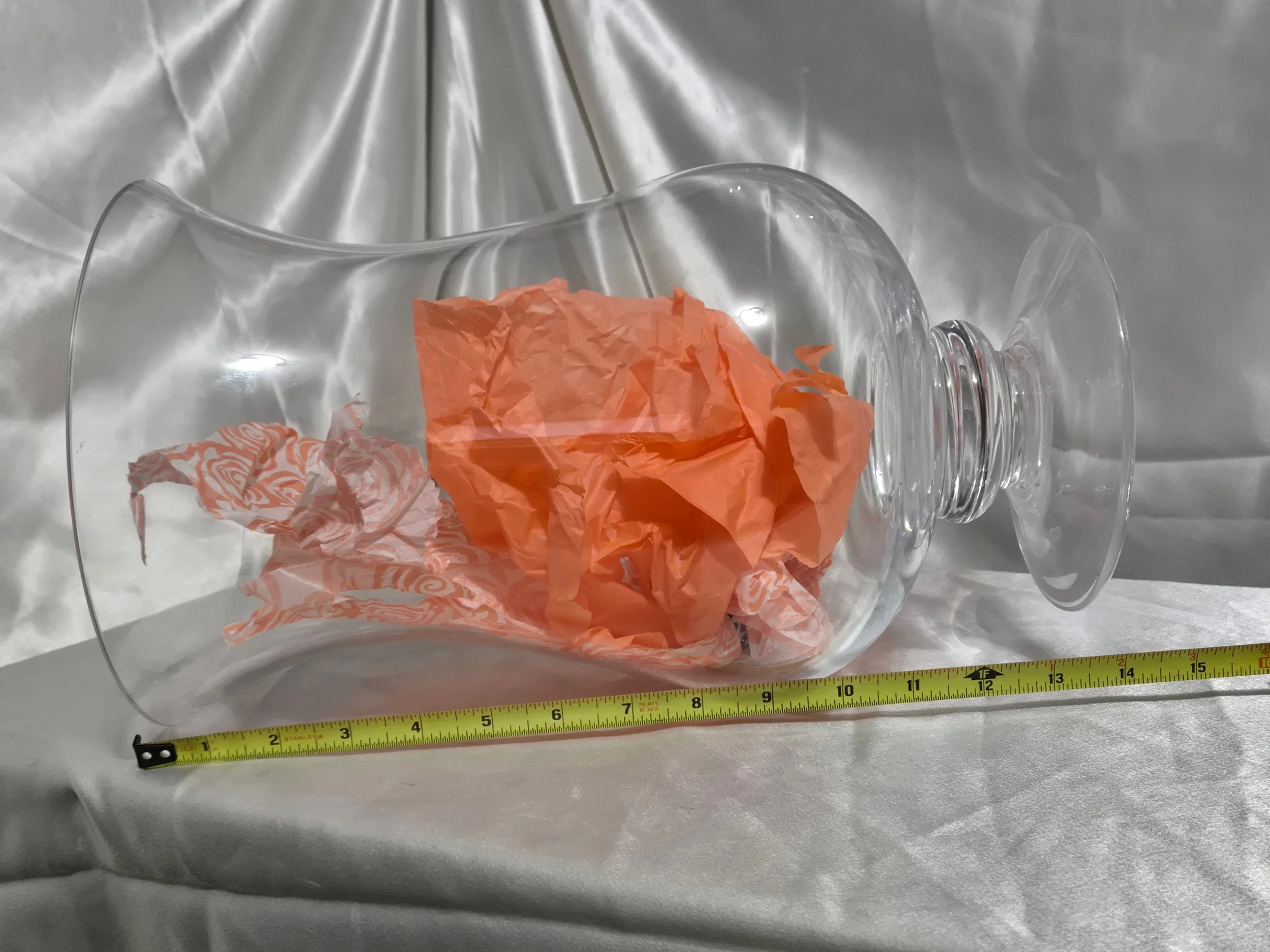 “Front view of tall clear glass pedestal hurricane vase with gently curved silhouette.