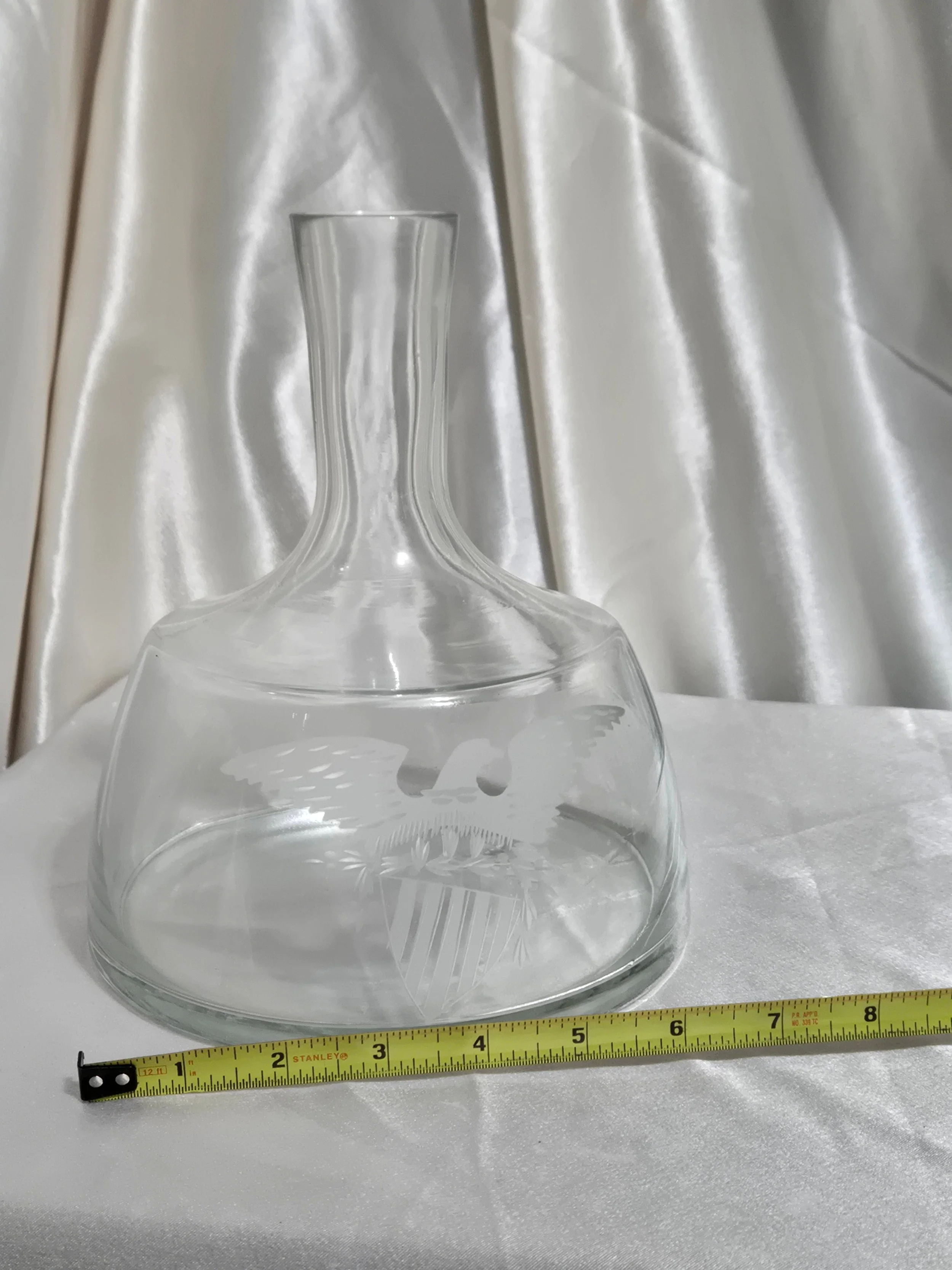 Top view of glass decanter with stopper removed showing wide opening and etched detail below rim