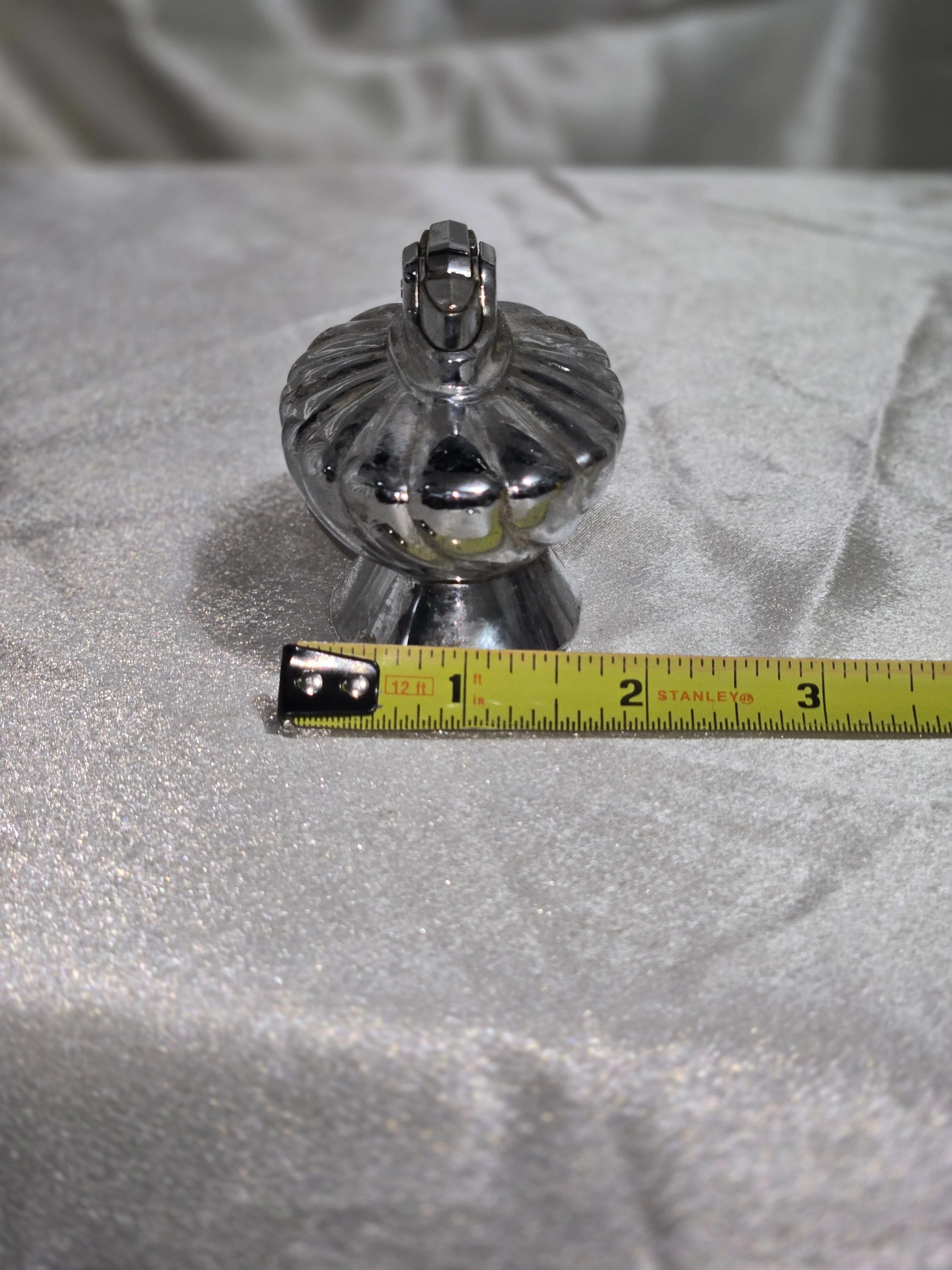 Vintage Ronson Regal chrome table lighter with swirl design, reflective silver finish, shown on silver backdrop.