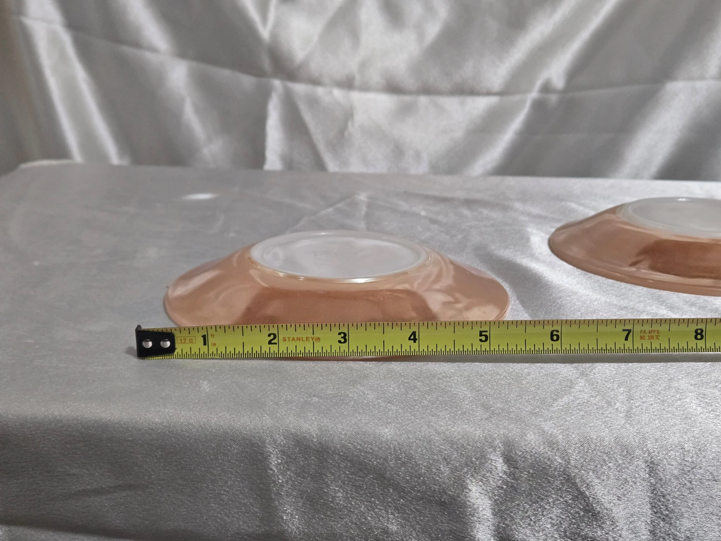 Set of Fire-King Peach Lustre saucers with iridescent sheen and vintage mid-century glow against white background.