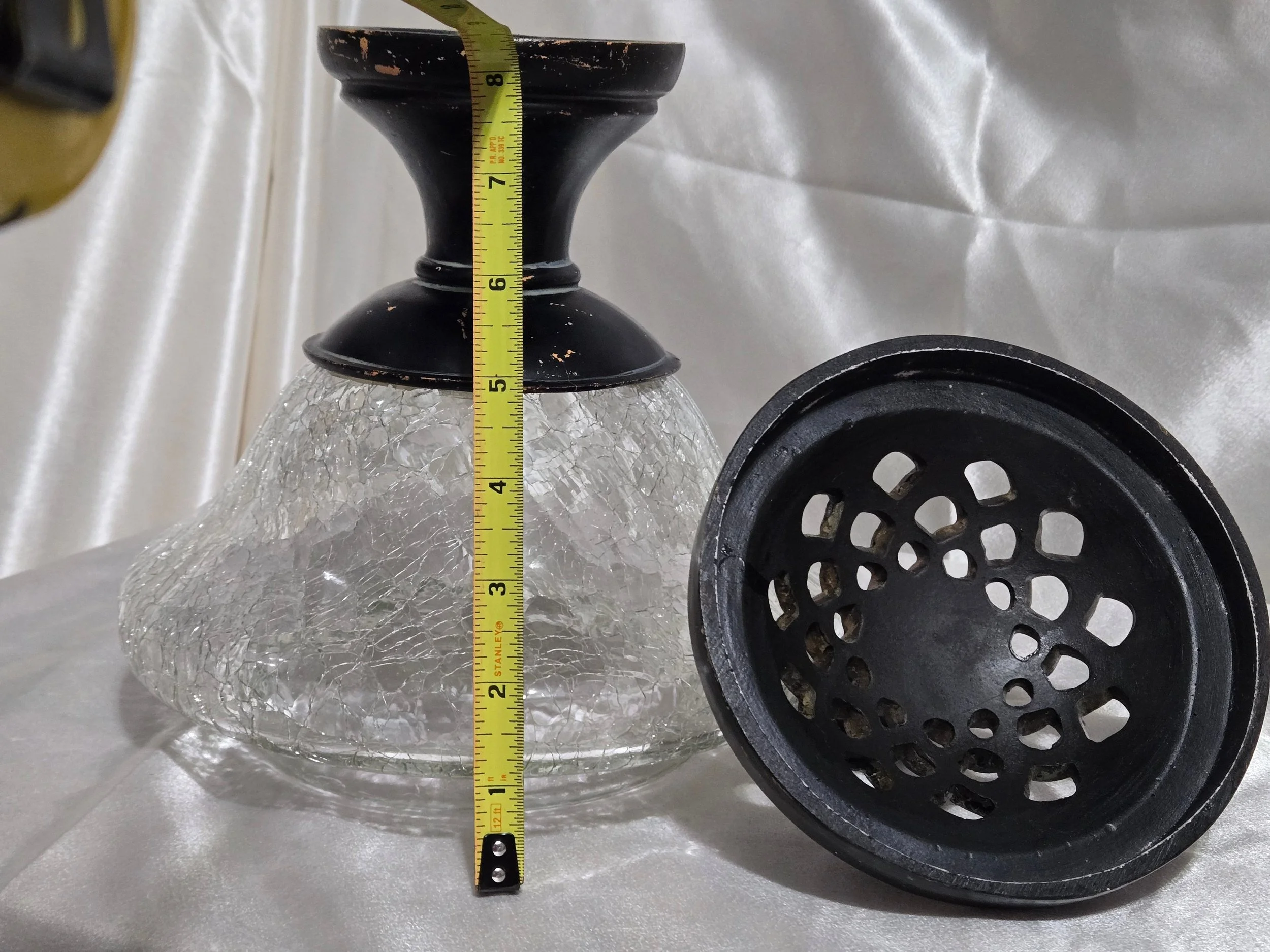 Vintage crackle glass apothecary jar with black metal lid and pedestal base, clear textured glass with distressed finish.