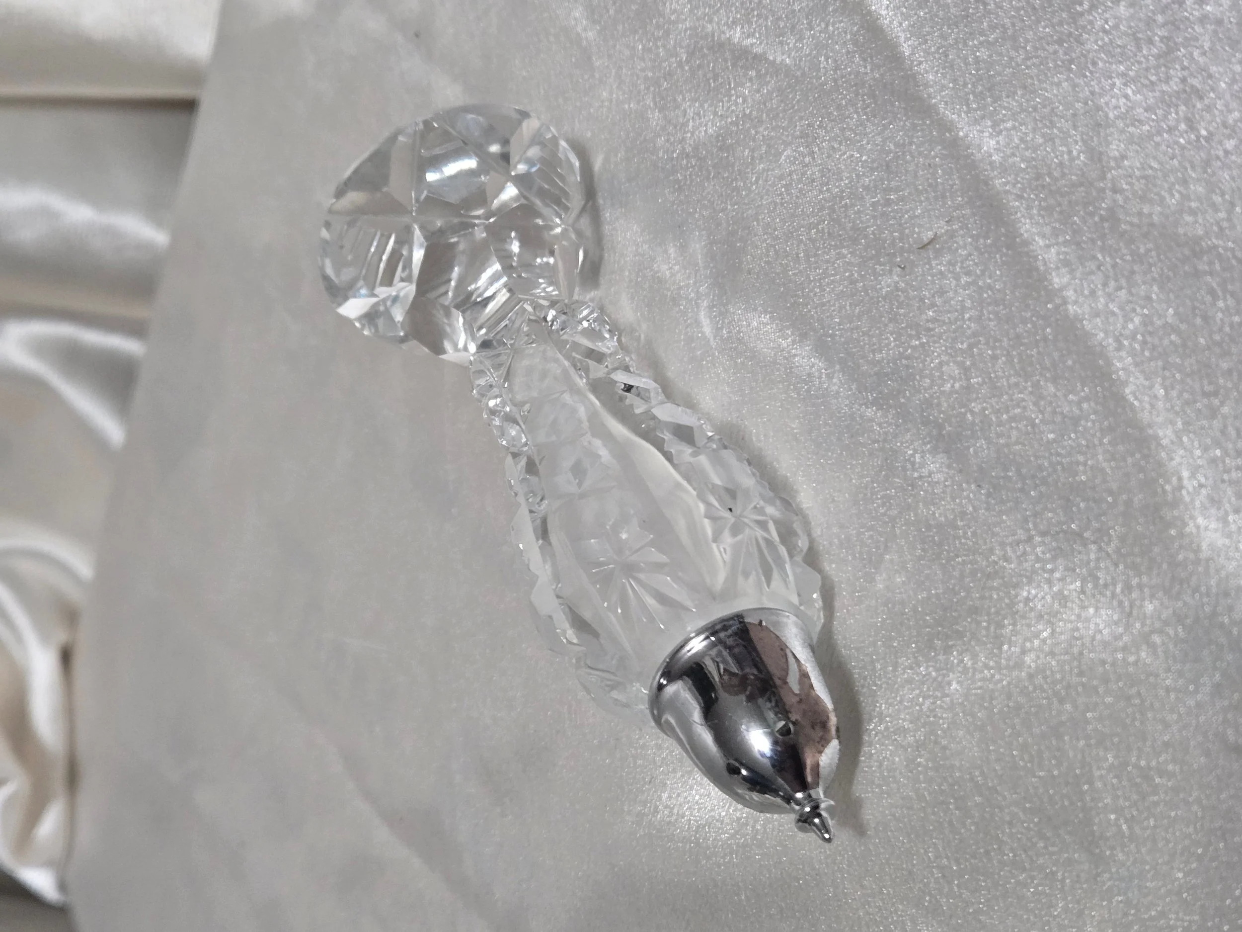 Crystal salt or pepper shaker lying on side to show length and cut glass detail