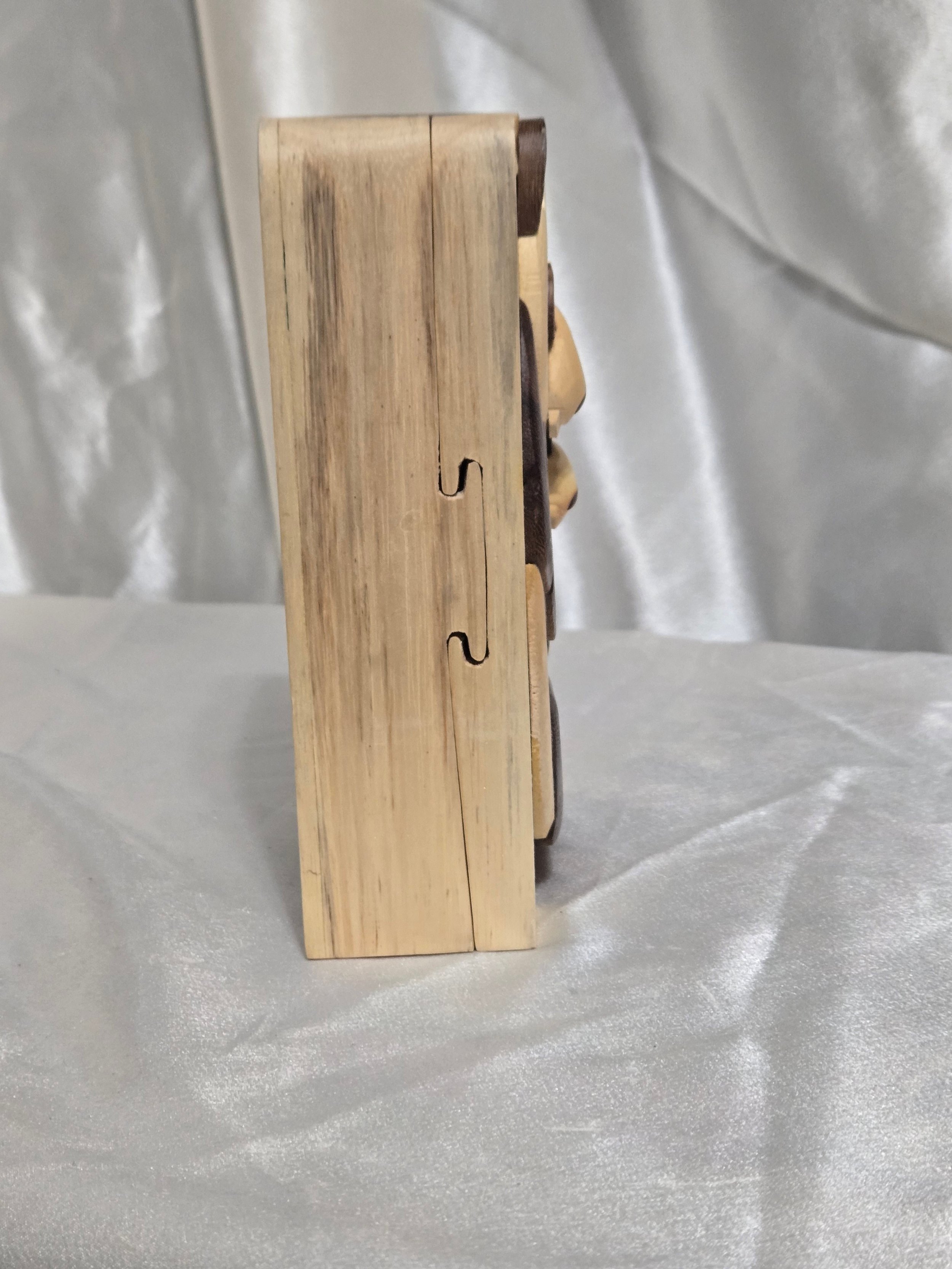 Side view of panda puzzle box showing joinery and hidden opening seam