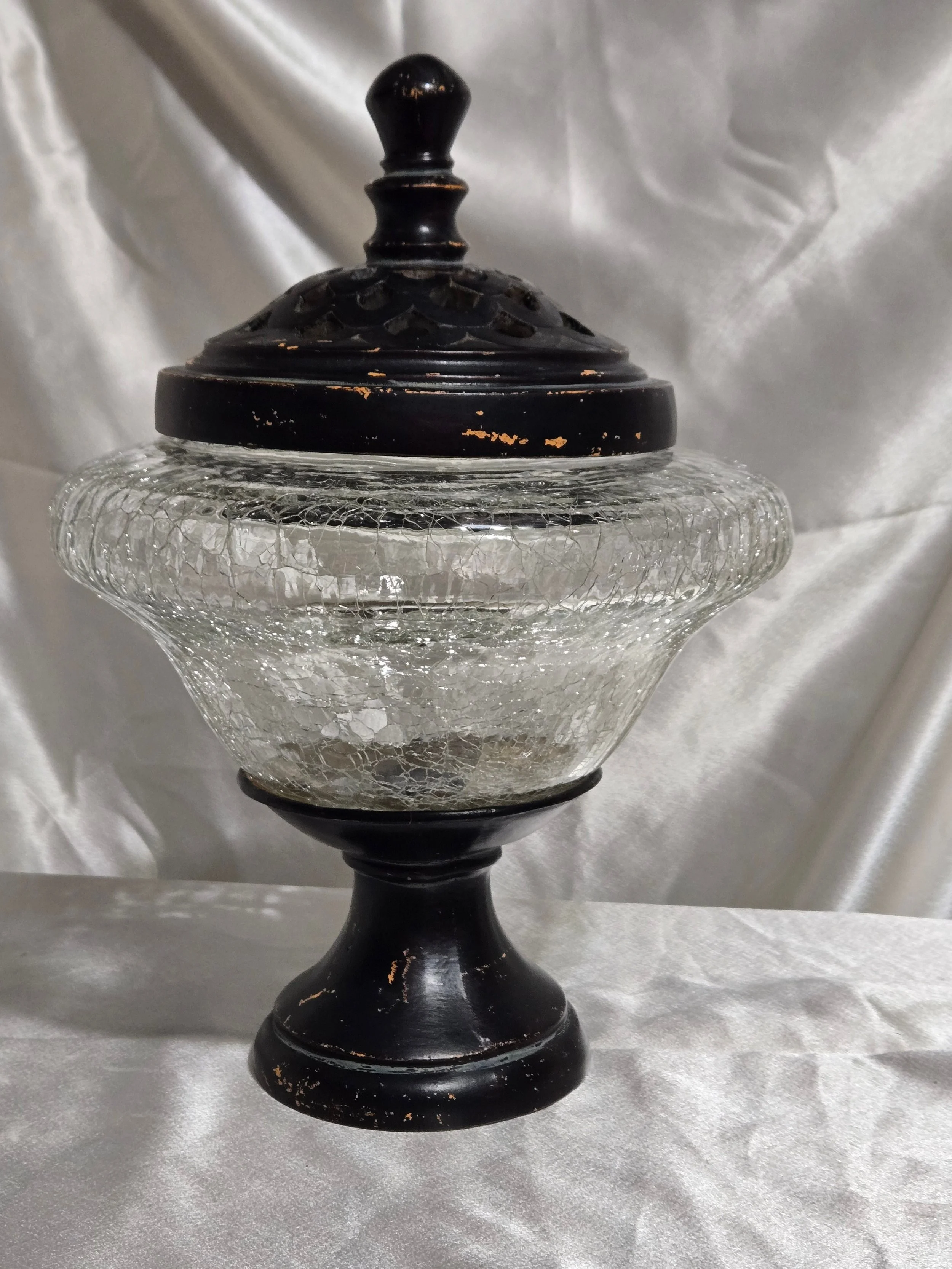 Vintage crackle glass apothecary jar with black metal lid and pedestal base, clear textured glass with distressed finish.