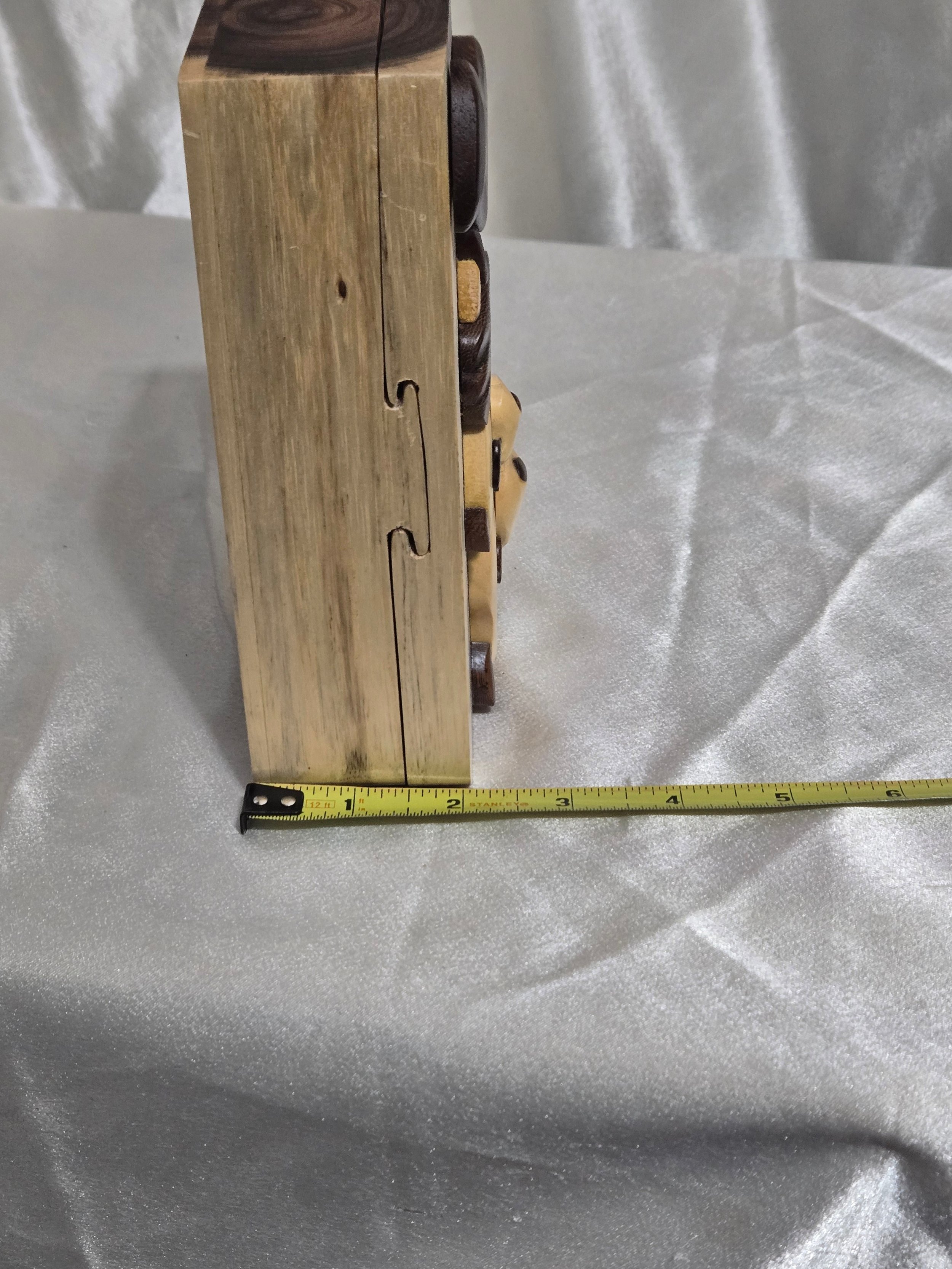 Side view of panda puzzle box showing joinery and hidden opening seam