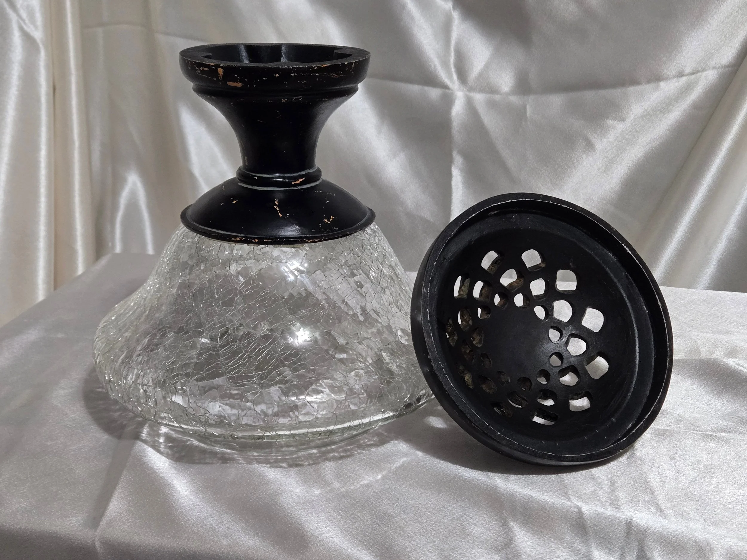 Vintage crackle glass apothecary jar with black metal lid and pedestal base, clear textured glass with distressed finish.