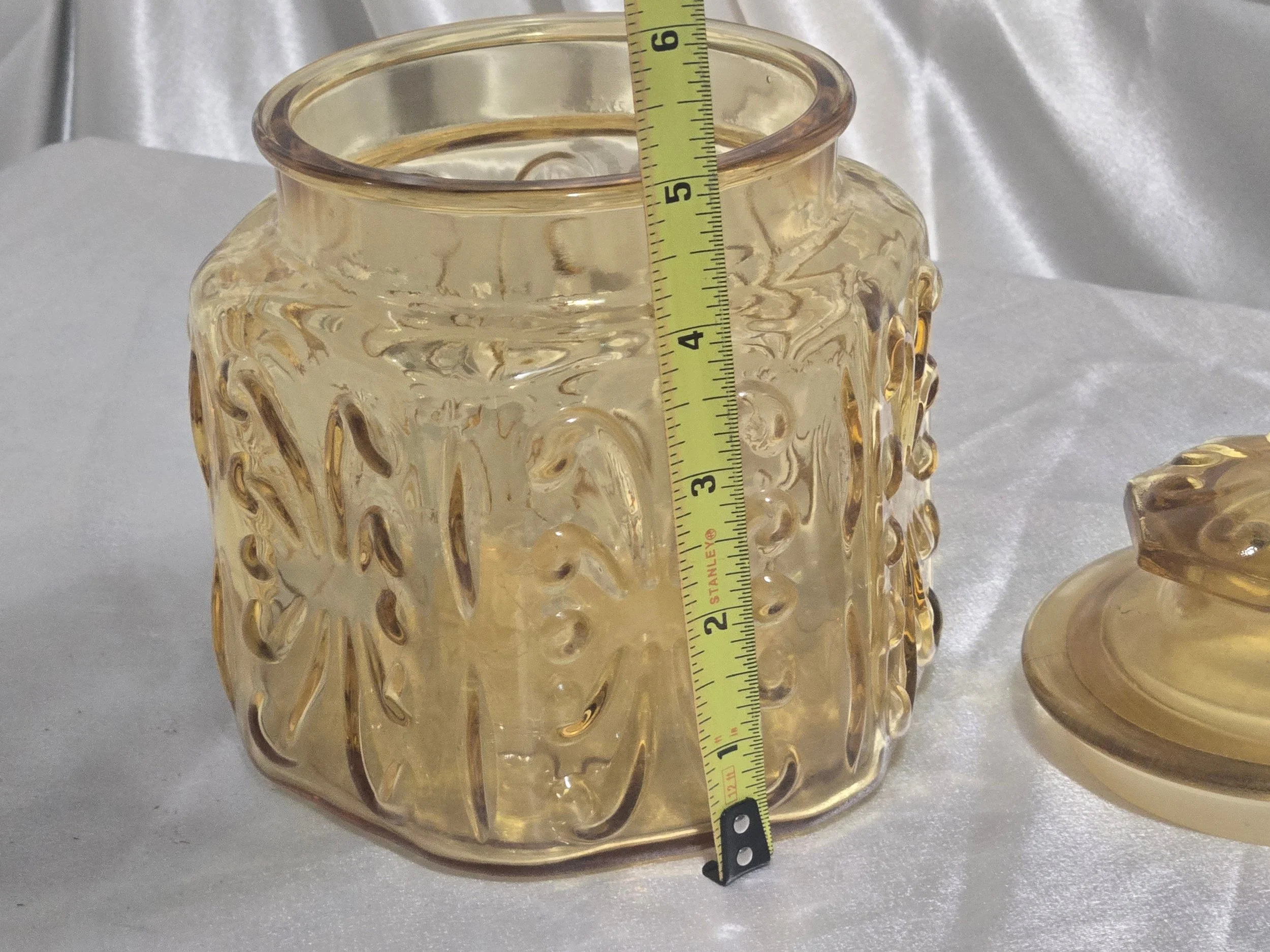 Ornate amber apothecary jar with floral scroll design, retro glass storage