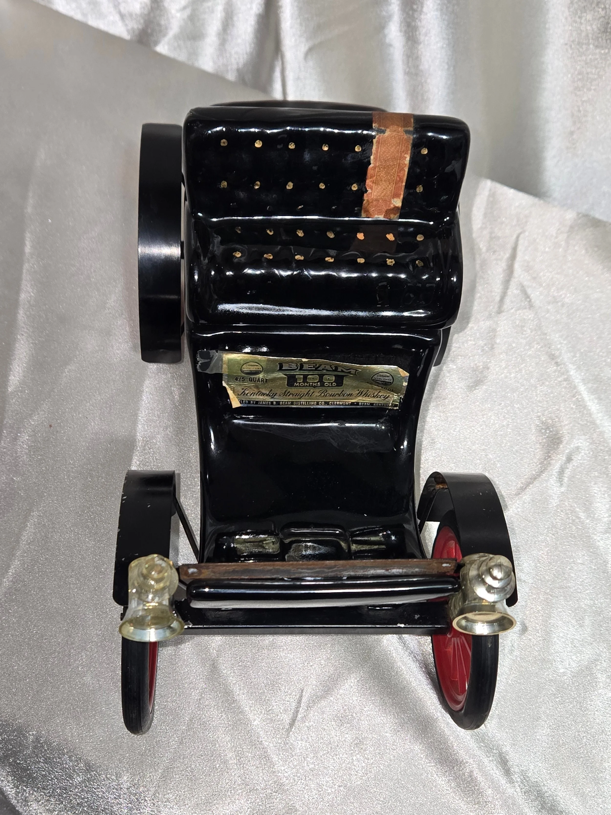 Close-up of Jim Beam branding and red wheel detail on vintage decanter