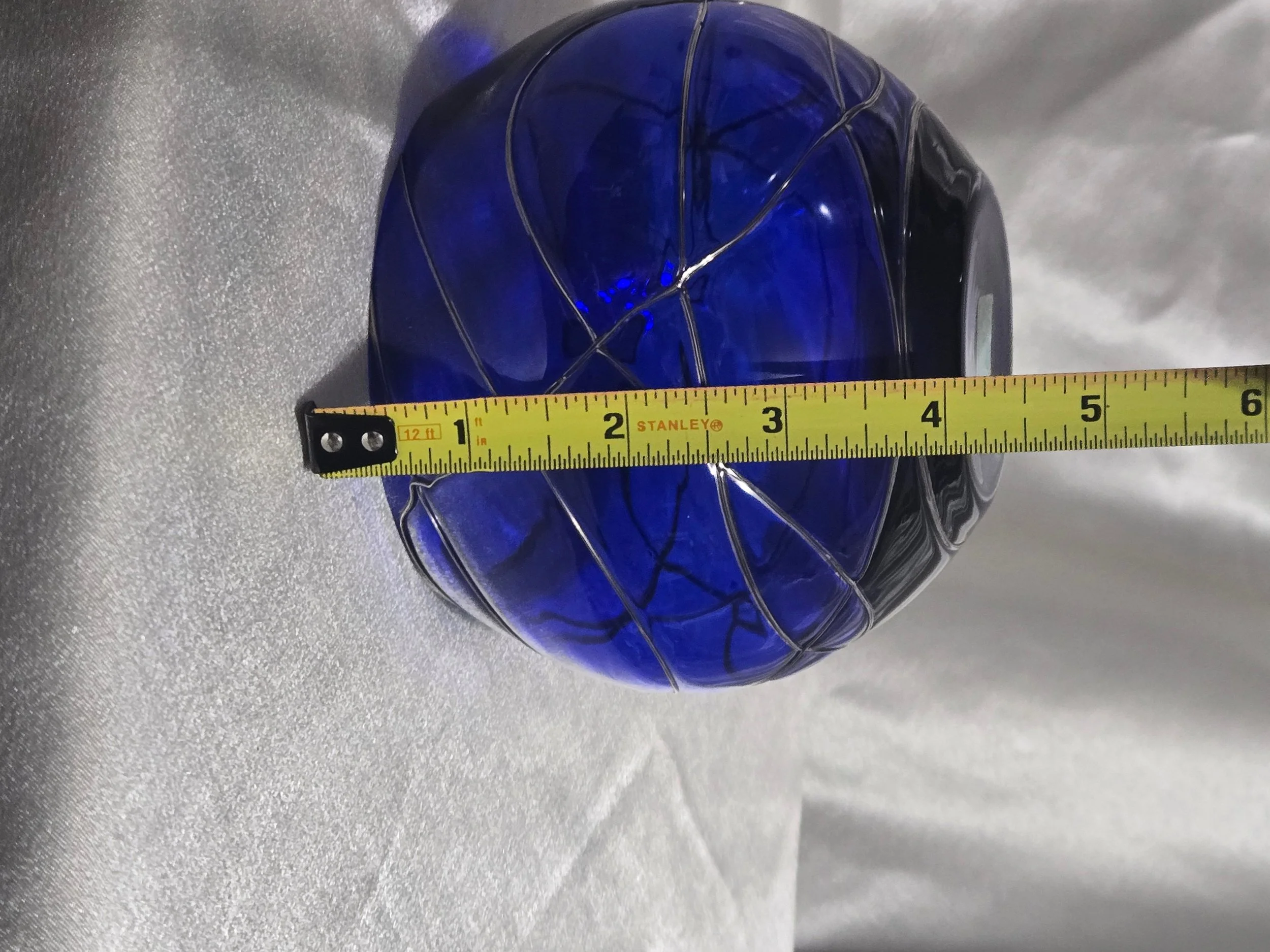 Cobalt blue hand-blown glass vase with silver swirl detailing, rounded art glass bowl, Murano-style decorative piece.