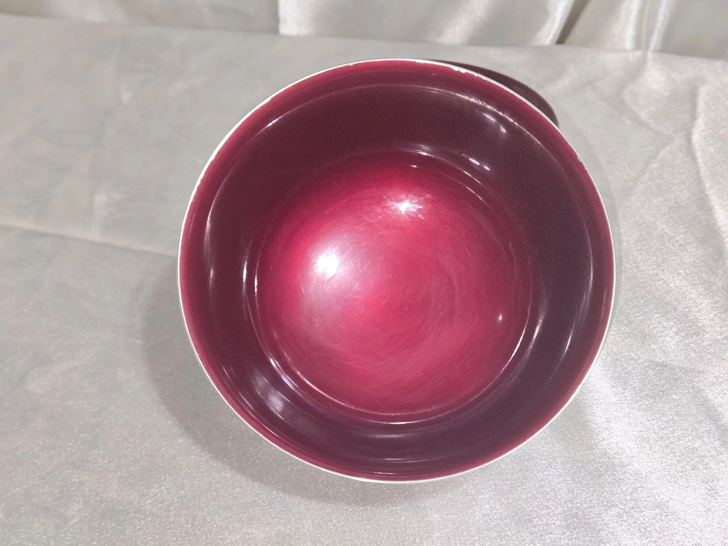 Close-up of ruby enamel interior in vintage silver bowl