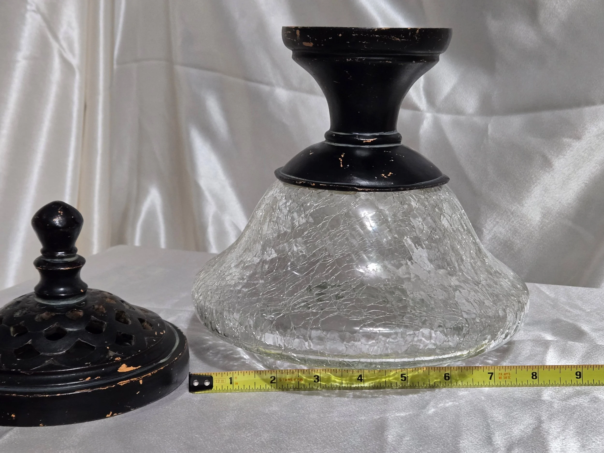 Vintage crackle glass apothecary jar with black metal lid and pedestal base, clear textured glass with distressed finish.