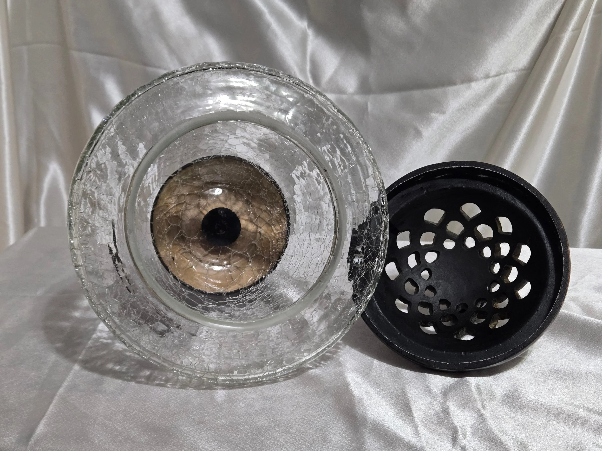 Vintage crackle glass apothecary jar with black metal lid and pedestal base, clear textured glass with distressed finish.