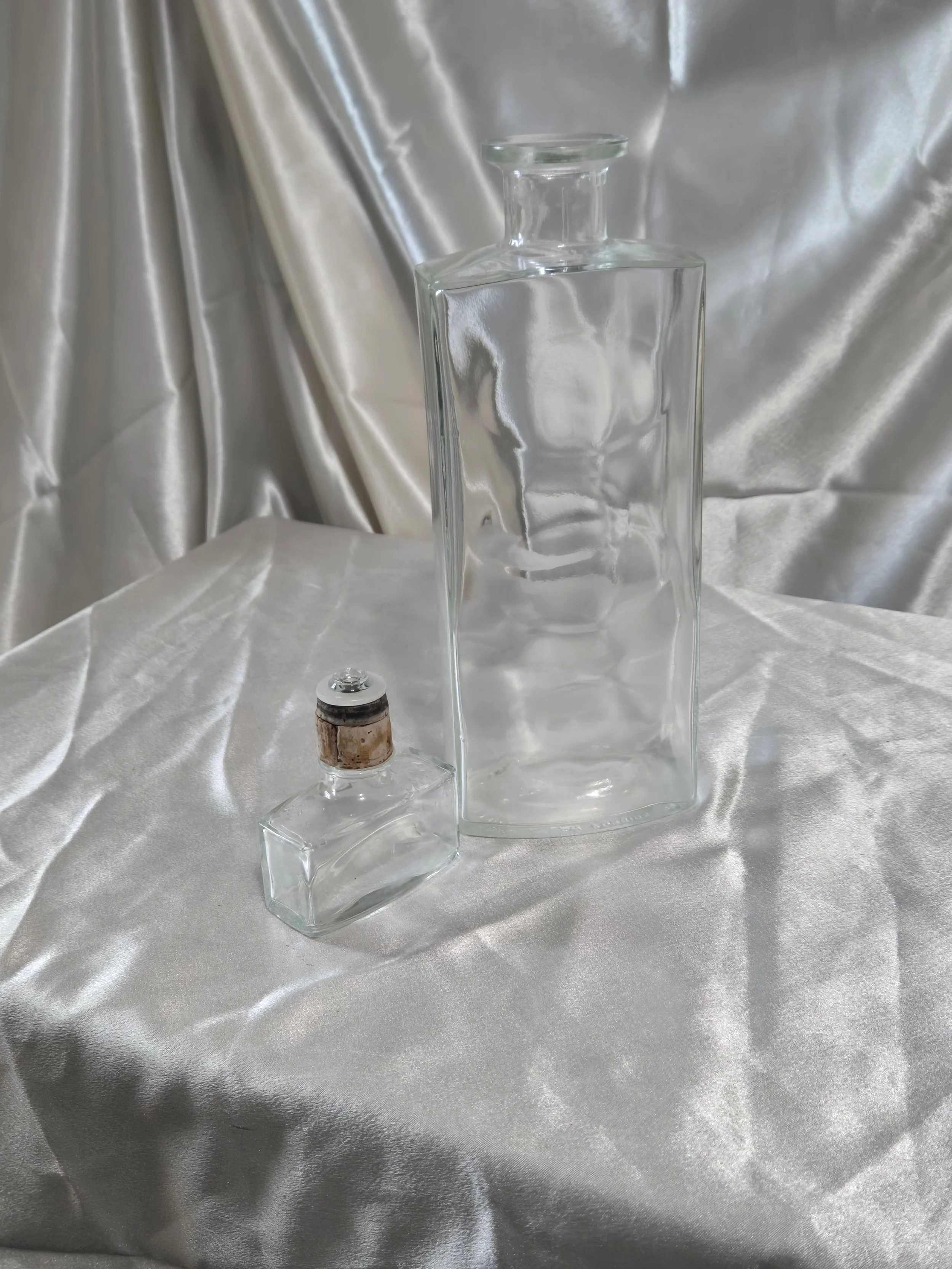 Vintage IW Harper bottle laying flat beside stopper, showing size