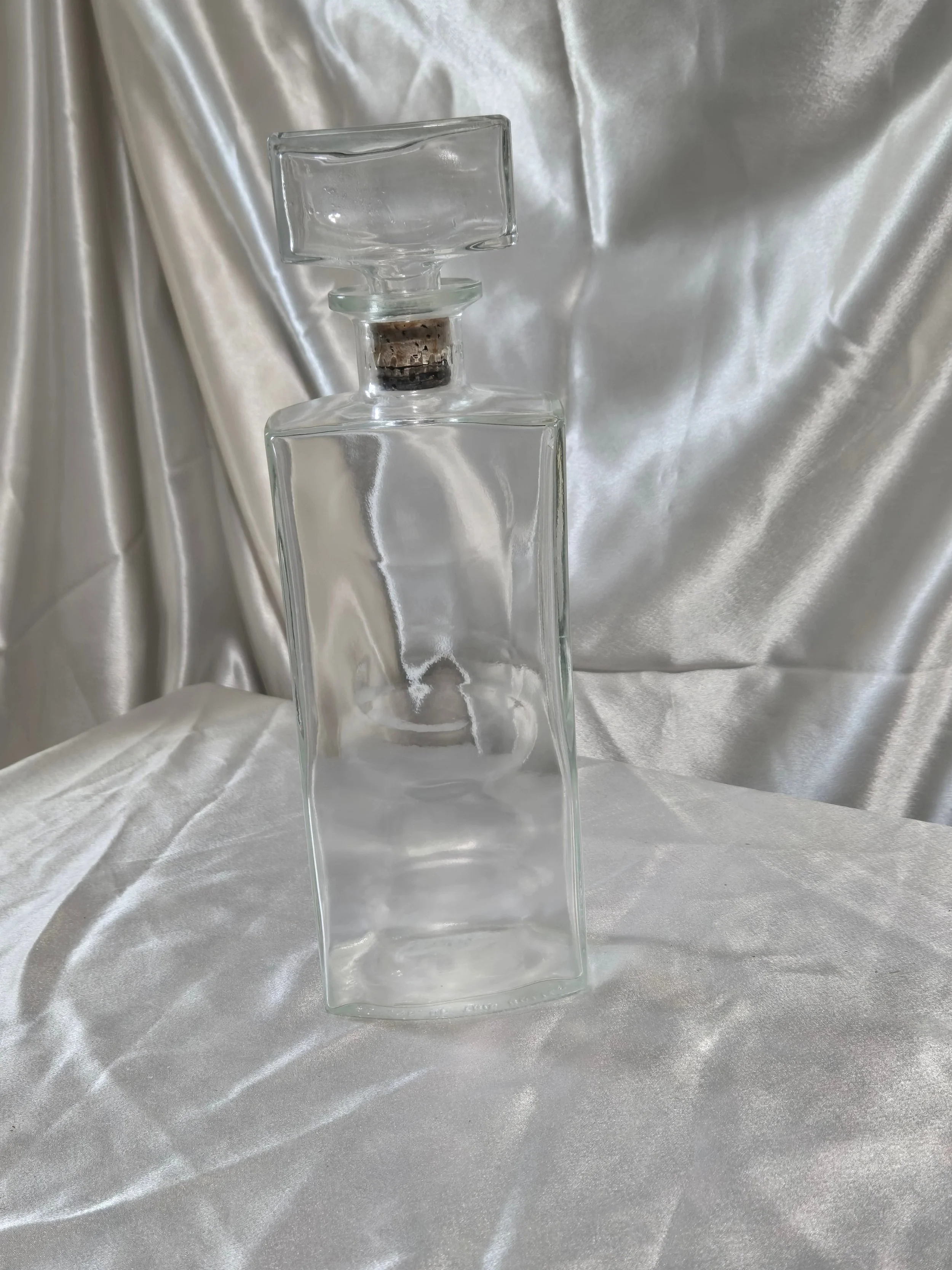 Vintage IW Harper bottle laying flat beside stopper, showing size
