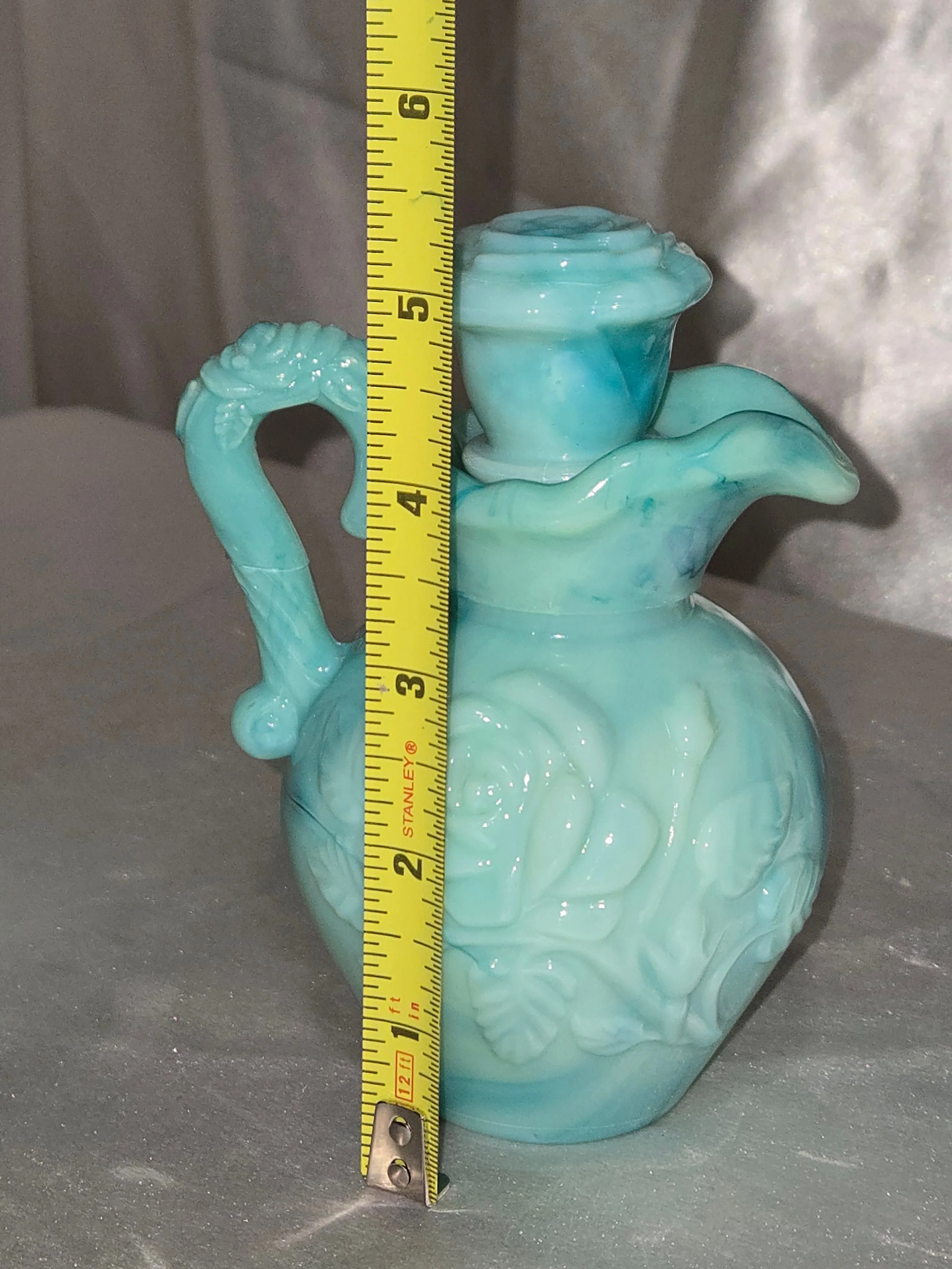 Side view of Avon milk glass pitcher showing soft green color and classic shape