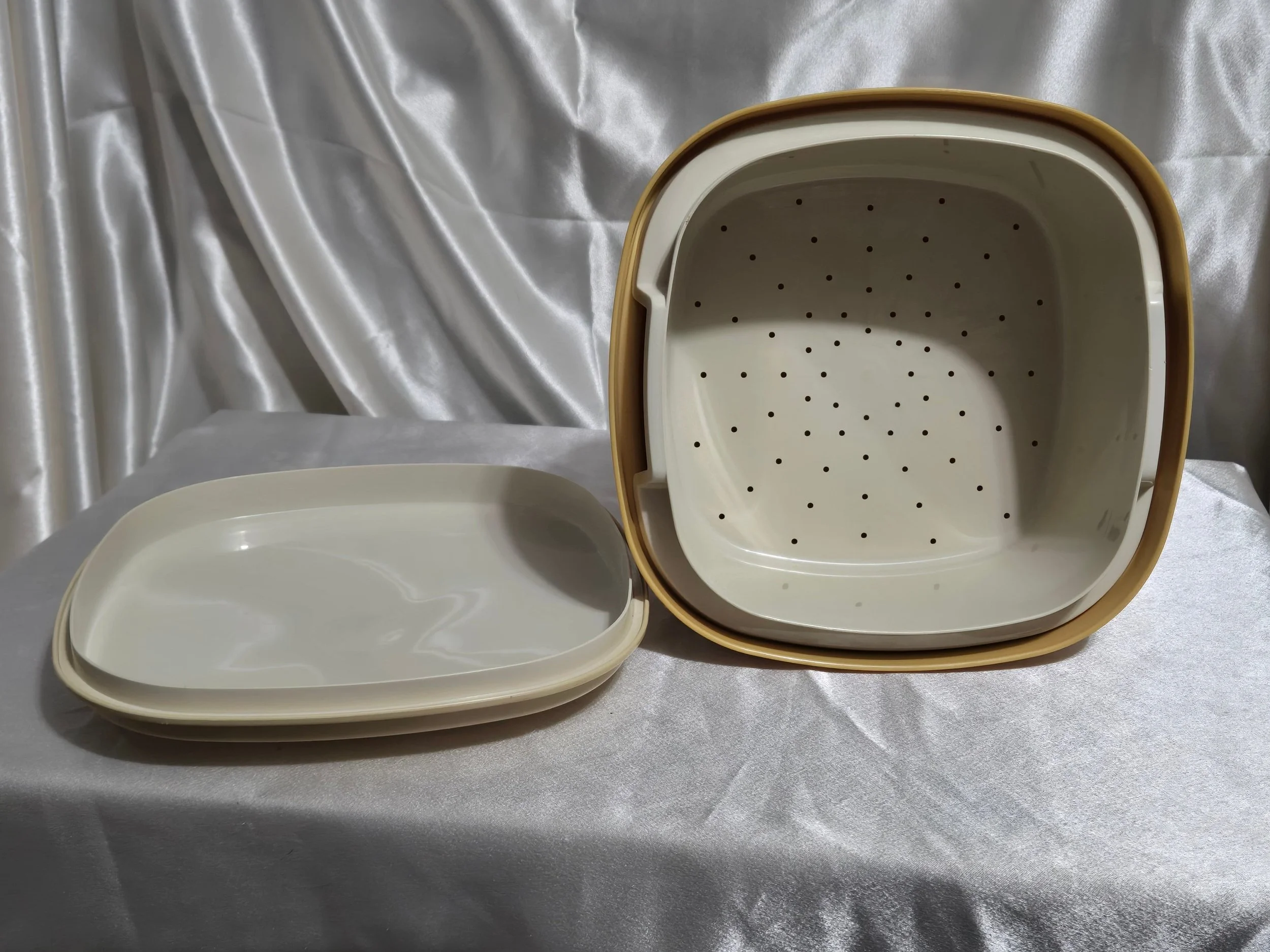 Vintage Tupperware microwave steamer in mustard yellow and ivory with lid, vented insert, and base shown together.