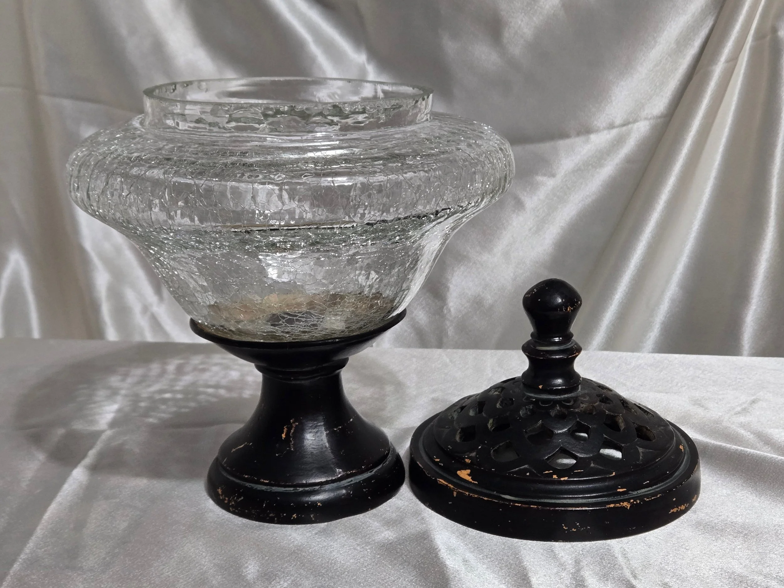 Vintage crackle glass apothecary jar with black metal lid and pedestal base, clear textured glass with distressed finish.