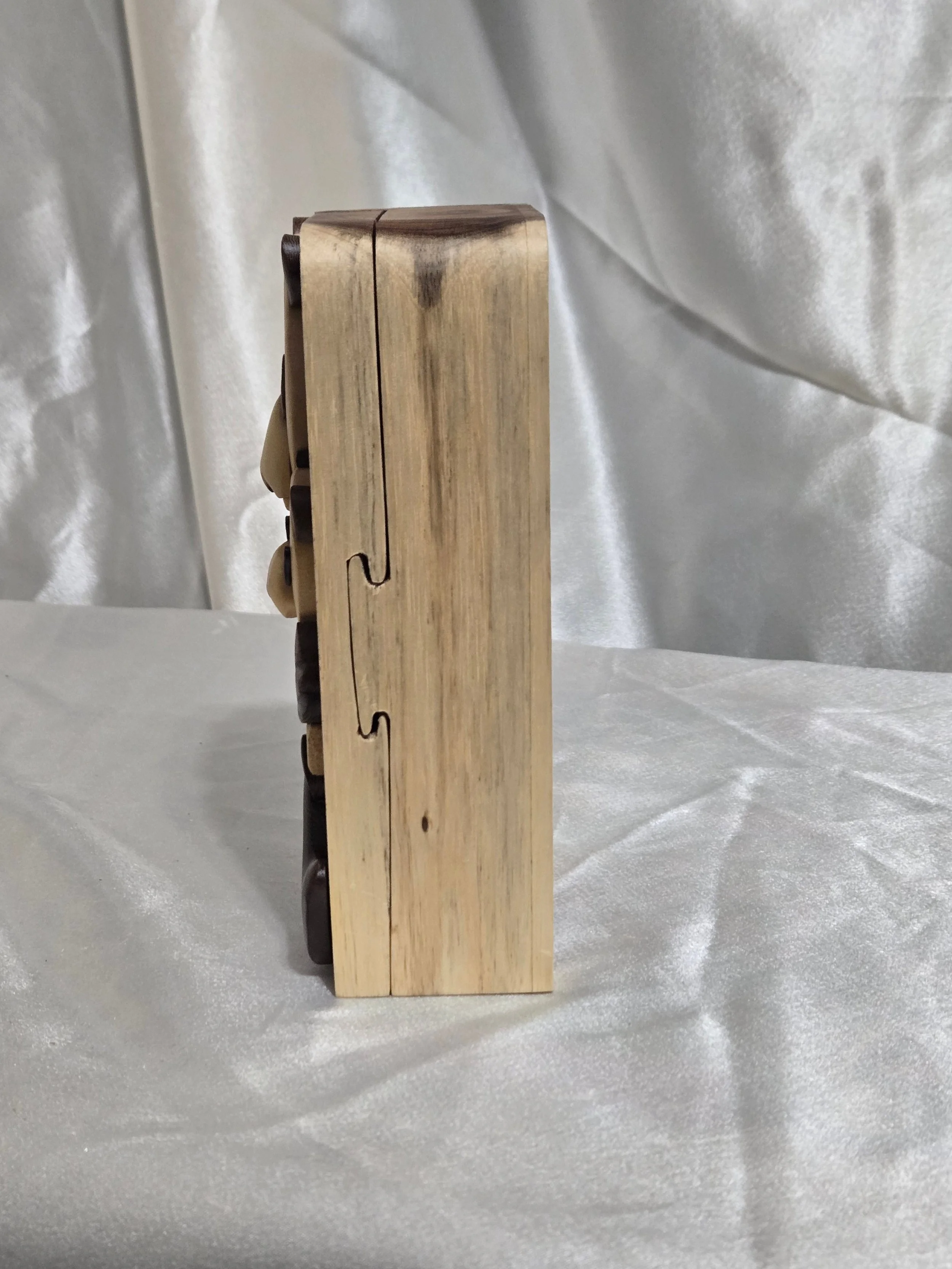 Side view of panda puzzle box showing joinery and hidden opening seam