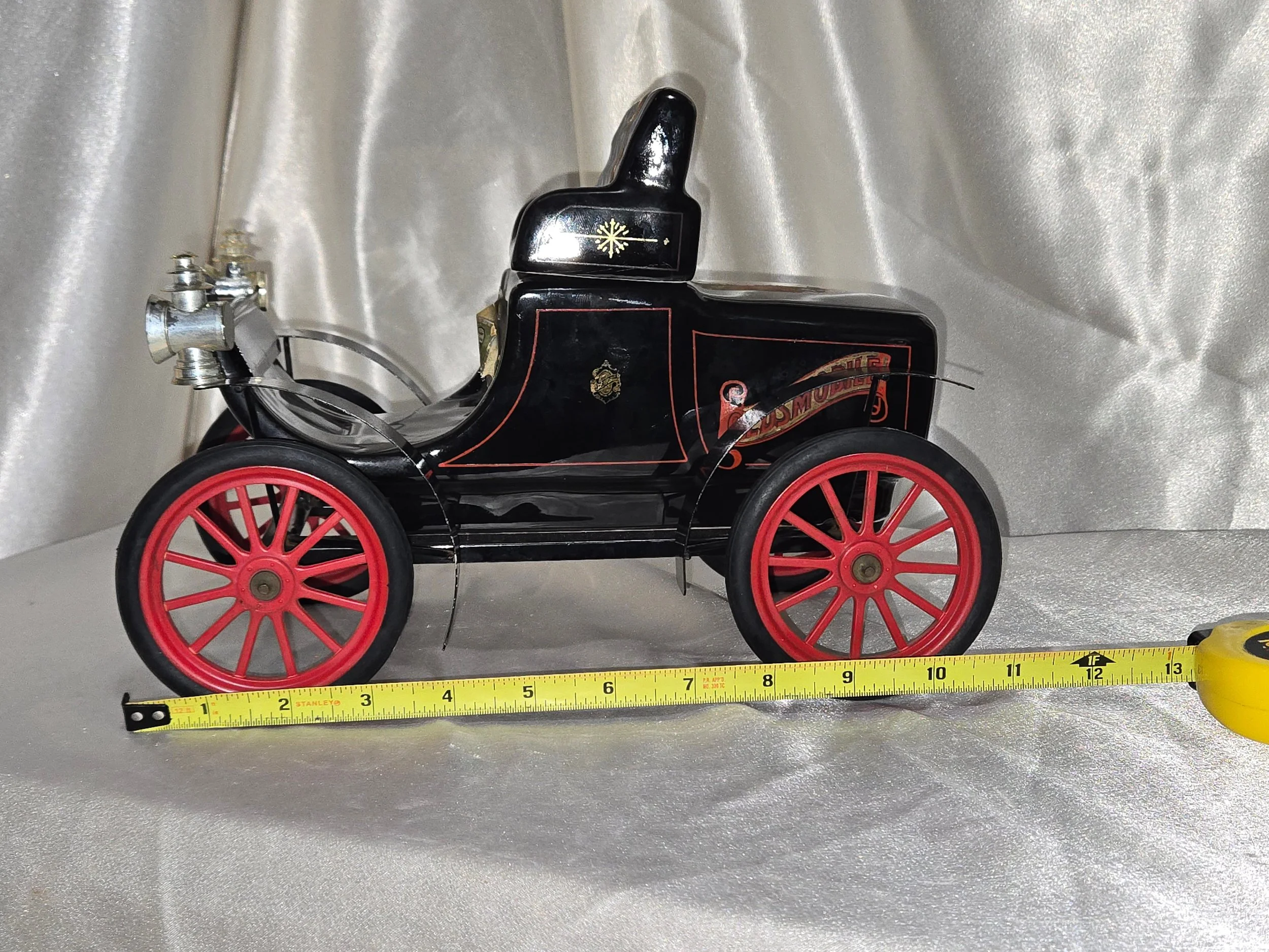 Vintage Jim Beam automobile decanter shown with measuring tape for size reference