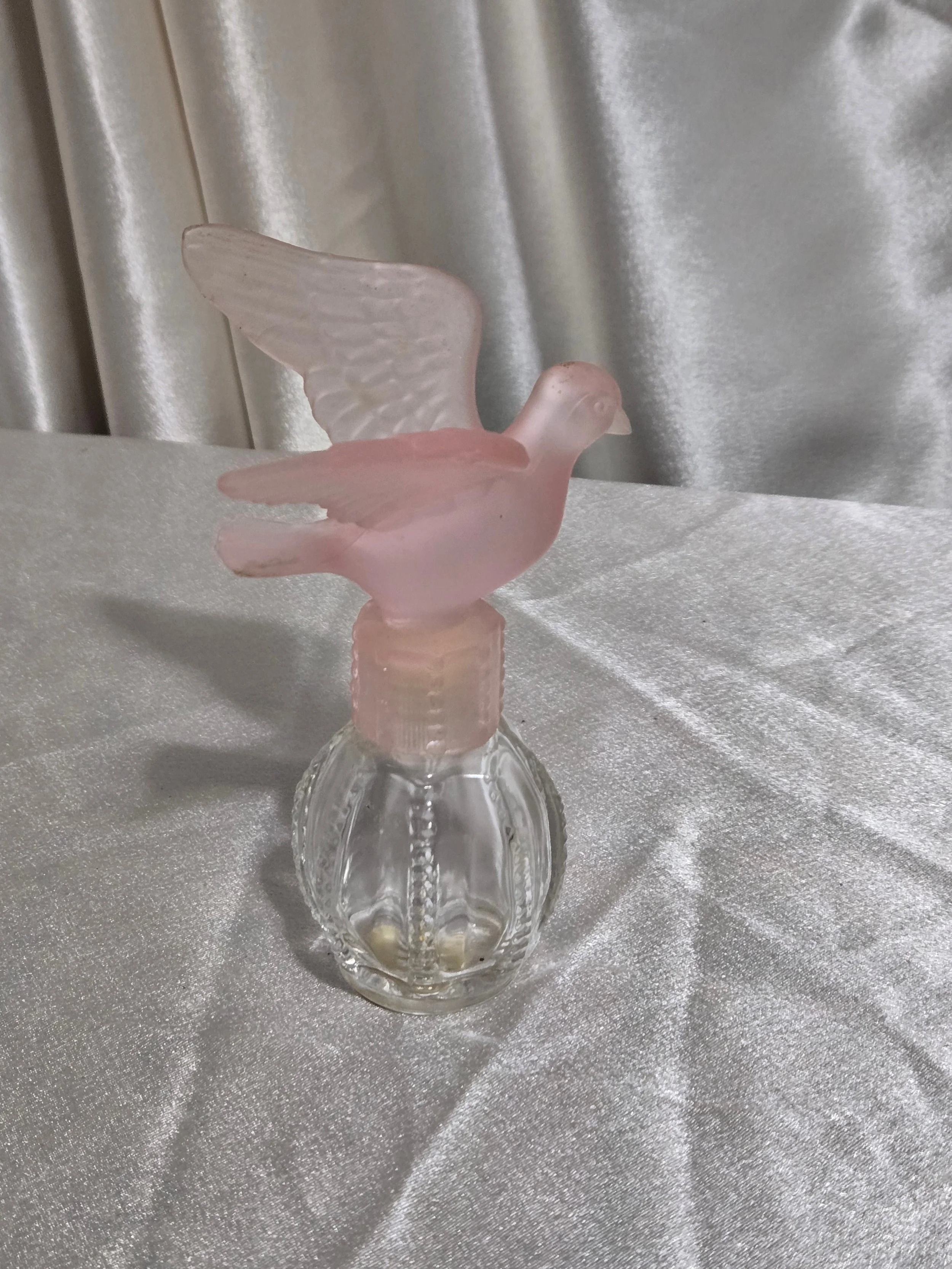 Side view of Avon Delager Royal pink dove perfume bottle highlighting sculpted wings