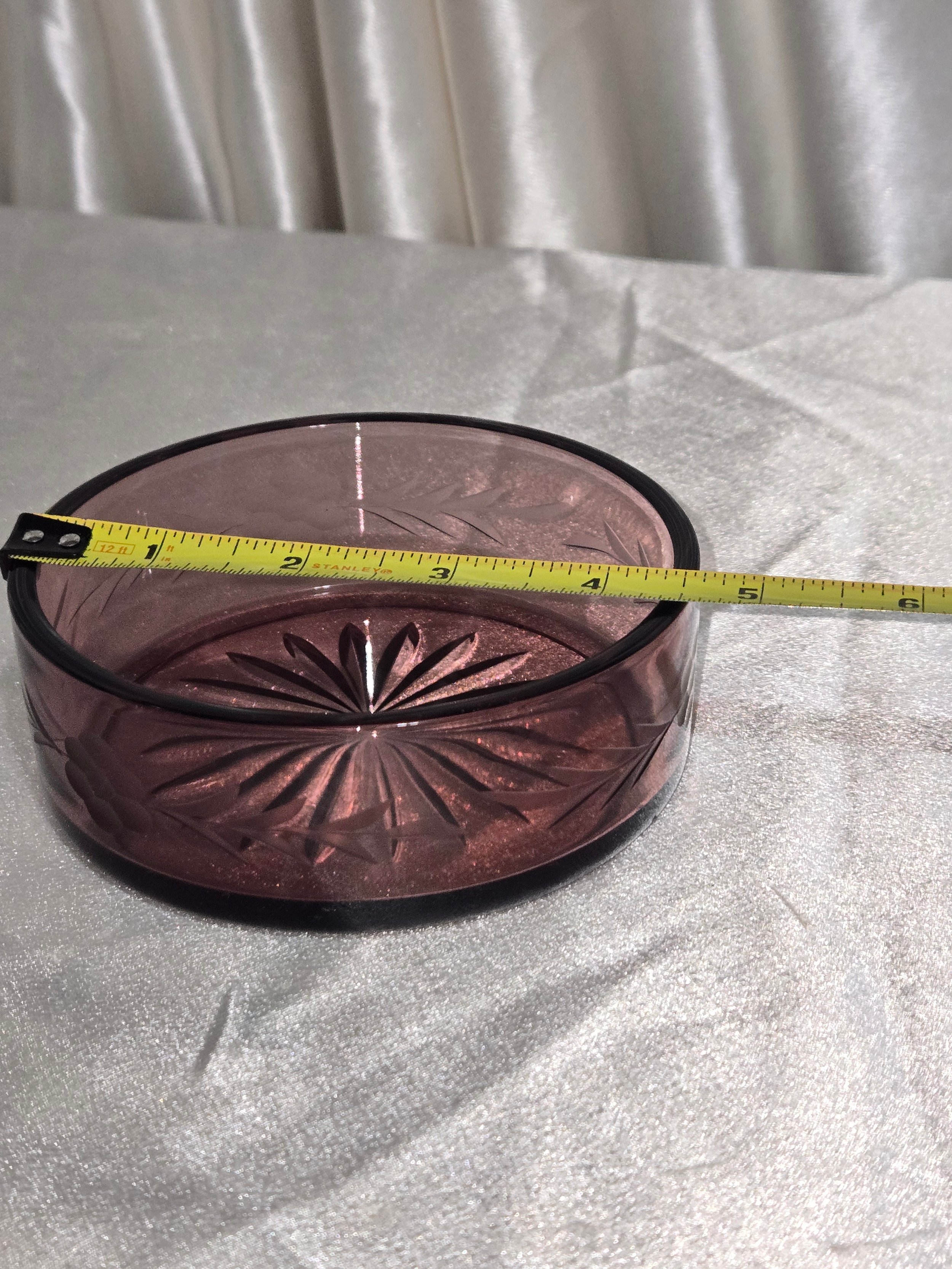 Decorative vintage purple glass bowl on table