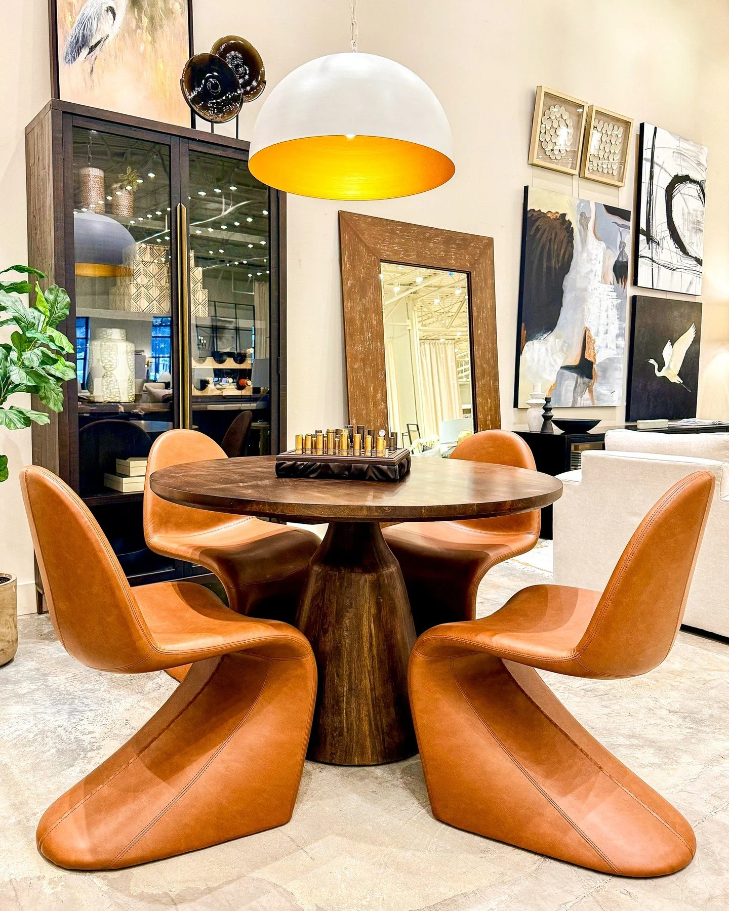 Game nights or dinner nights... either way, this table sets the tone.

Sculptural cognac leather chairs gather around a rich wood pedestal, creating a space that feels warm, modern, and made for lingering long after the plates are cleared. ✨