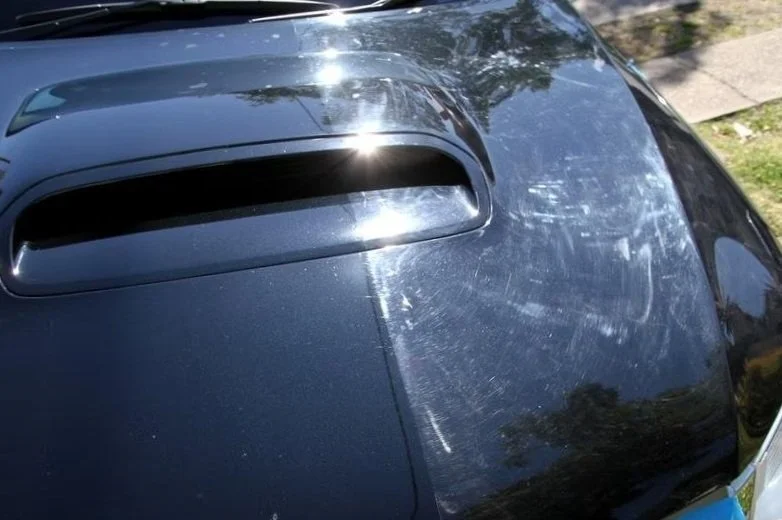 Zwarte auto met een grote krab op de motorkap en een luchtinlaat op het dak