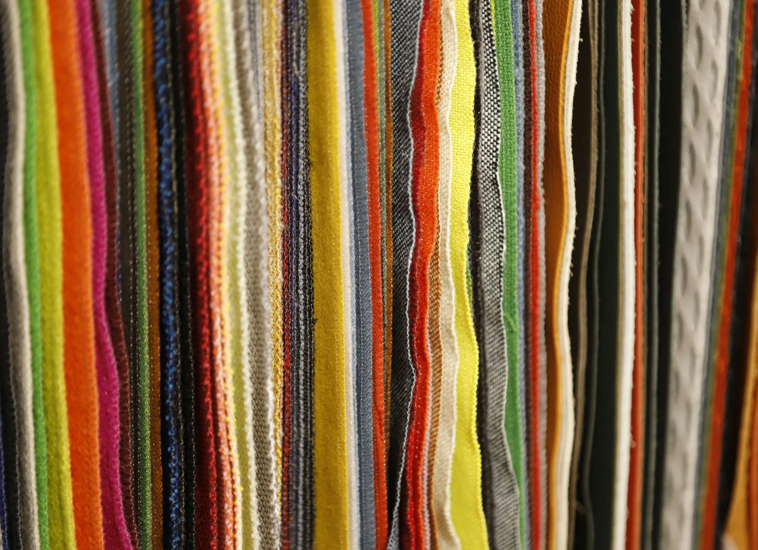 A variety of fabric swatches with different colors and textures, arranged vertically.