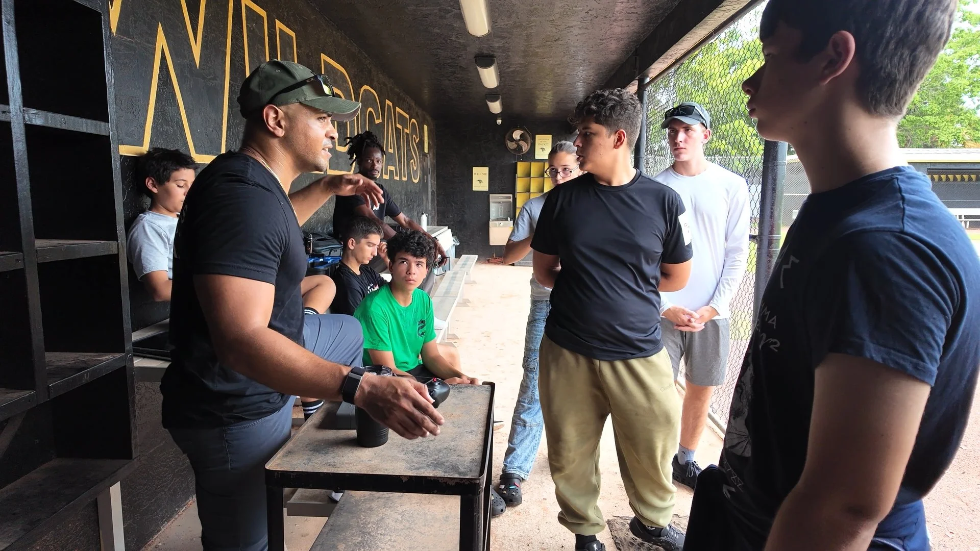 Kevin Padilla mentoring Western High JROTC drone team cadets with a drone controller.