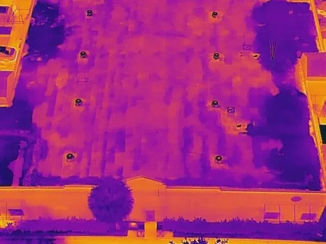AeroVis aerial thermal roof inspection showing heat signature anomalies, with dark zones indicating trapped moisture and insulation gaps invisible to visual inspection