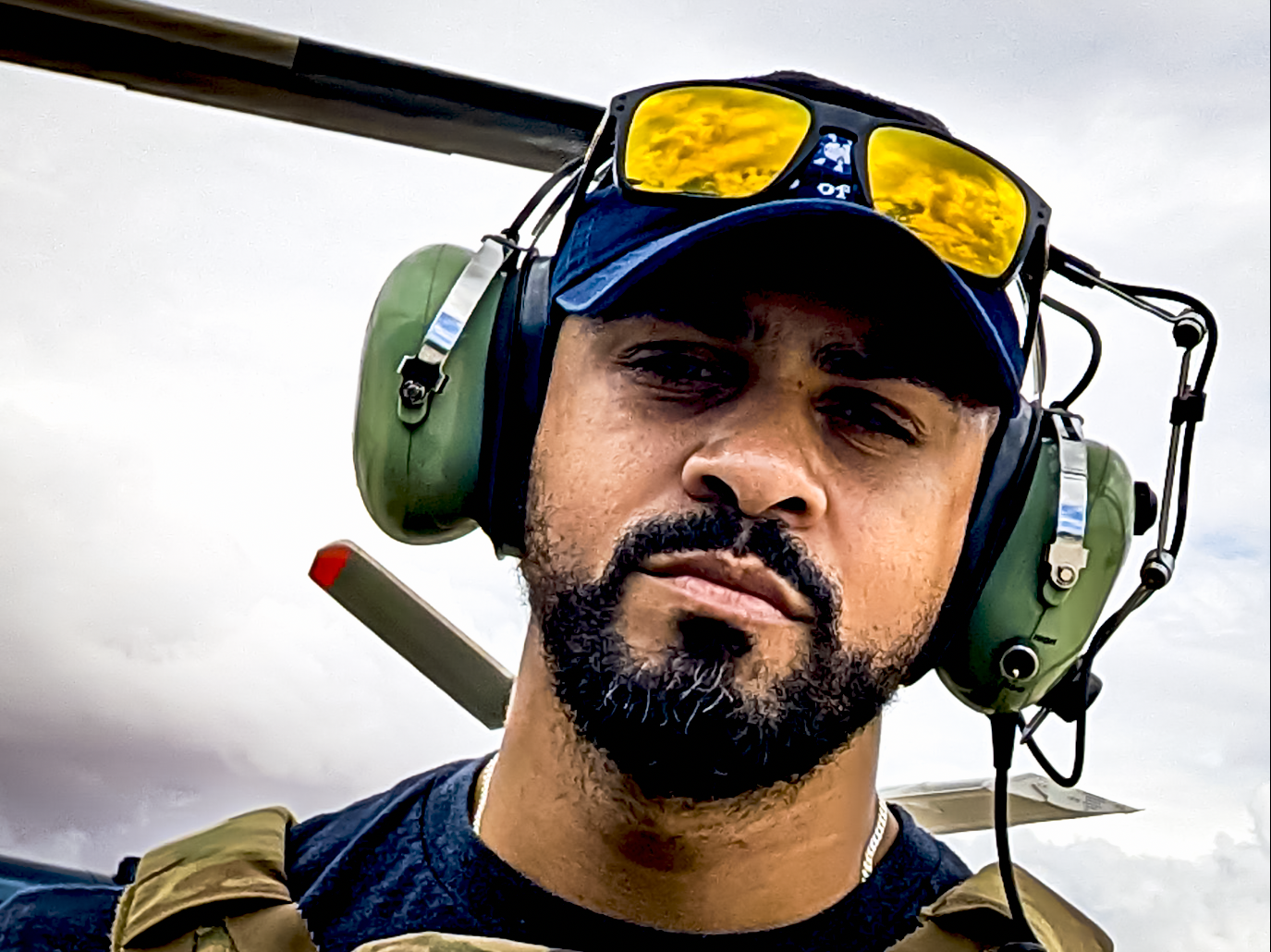 Kevin Padilla, veteran contract pilot and founder of Aerovis drone solutions, in flight gear beside an aircraft during a civilian contracted mission.