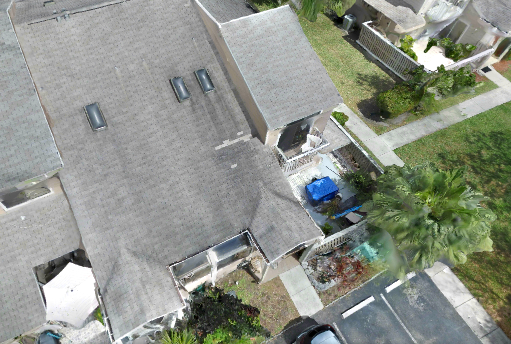 Drone view of a residential shingle roof with skylights for roof inspection and roofing assessment