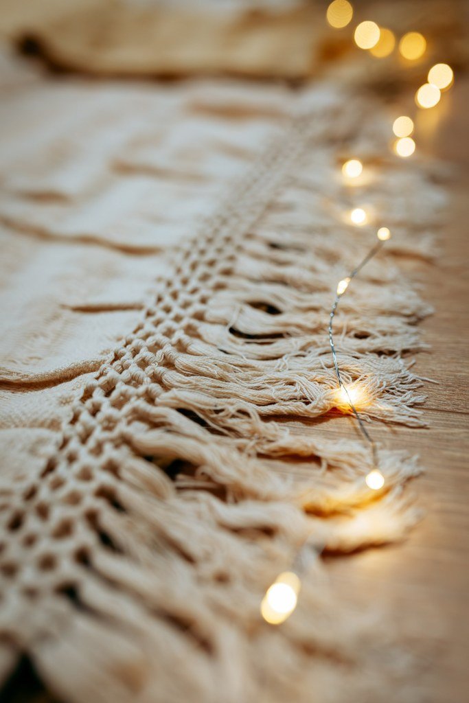 Un châle en tissu mexicain à franges appellé rebozo  accompagnée d'une guirlande lumineuse à petites ampoules.