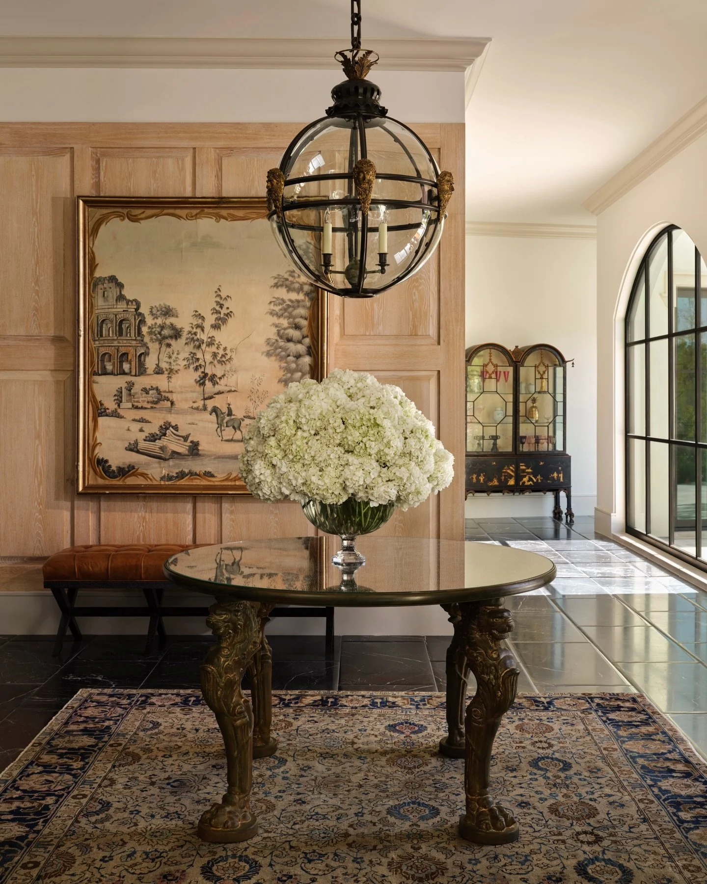 We choose pieces for their ability to endure. As you enter a room, it&rsquo;s these objects that immediately shift the register. Here, a Globe lantern  introduces sculptural tension overhead; below it, a lion paw center table asserts weight and propo